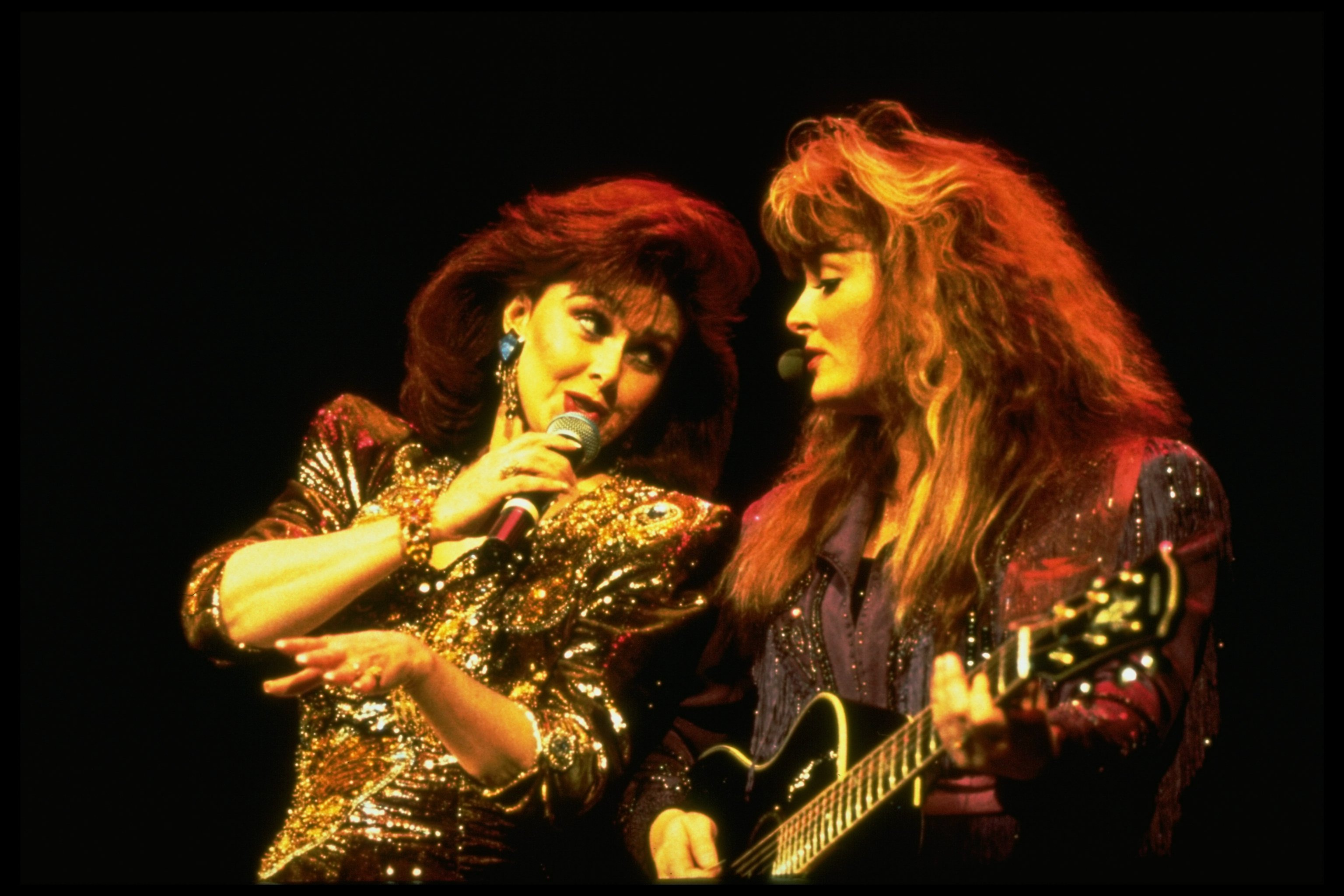 Naomi and Wynonna Judd singing in concert in 1990. | Source: Ron Wolfson/Getty Images