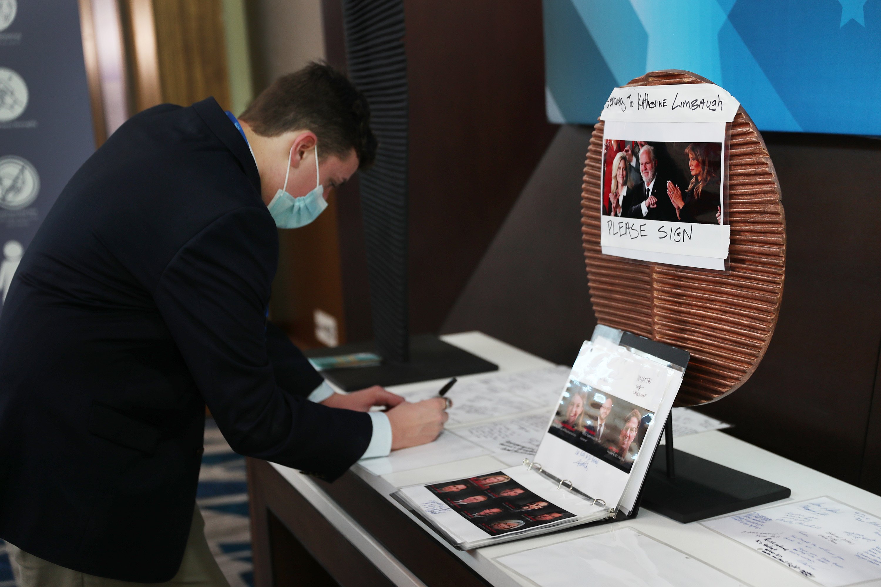 Easton Urbanek writes a message in a memorial honoring Rush Limbaugh at the Conservative Political Action Conference held in the Hyatt Regency on February 27, 2021 in Orlando, Florida. | Source: Getty Images