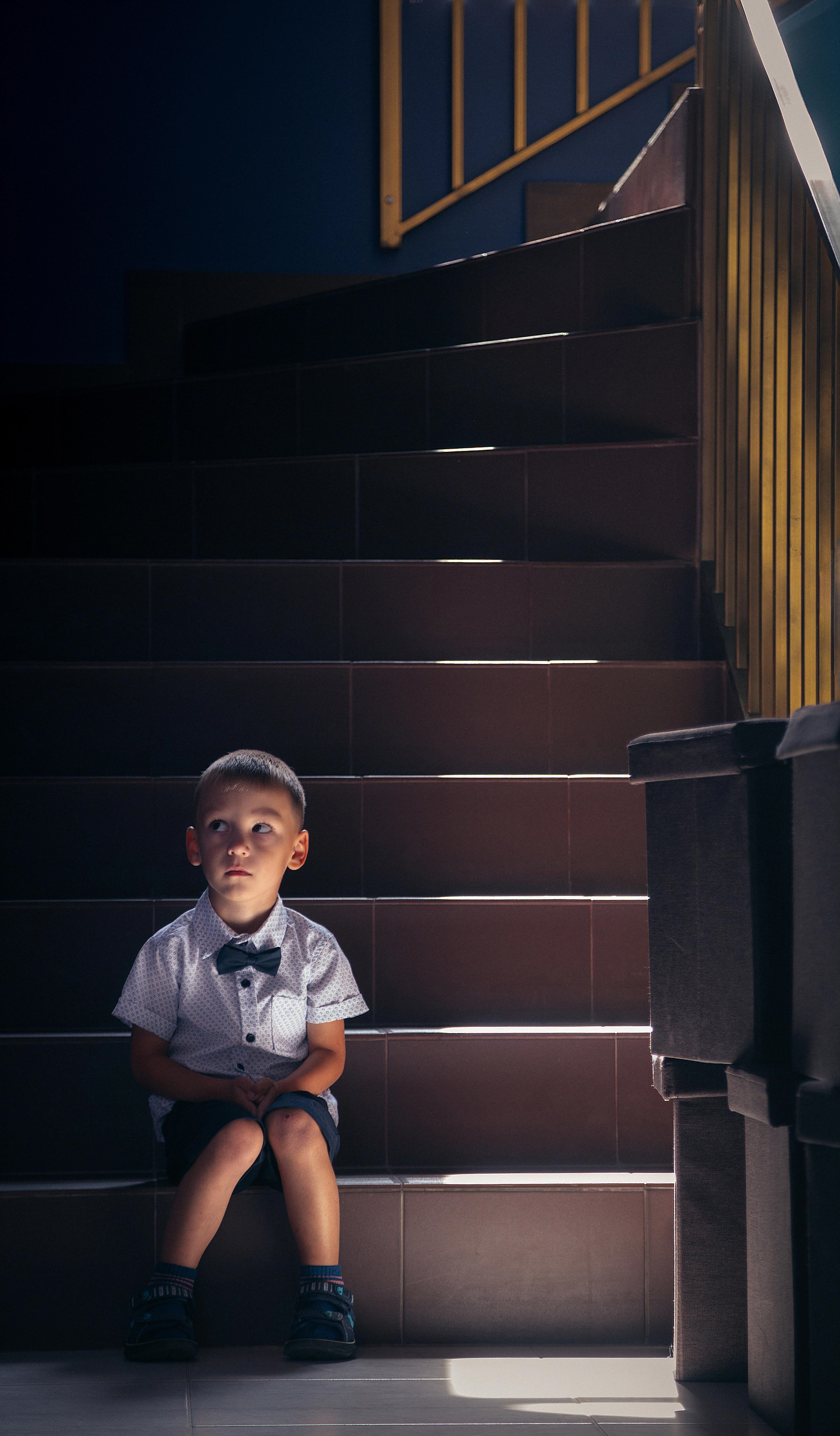 Niño sentado en una escalera. | Foto: Pexels