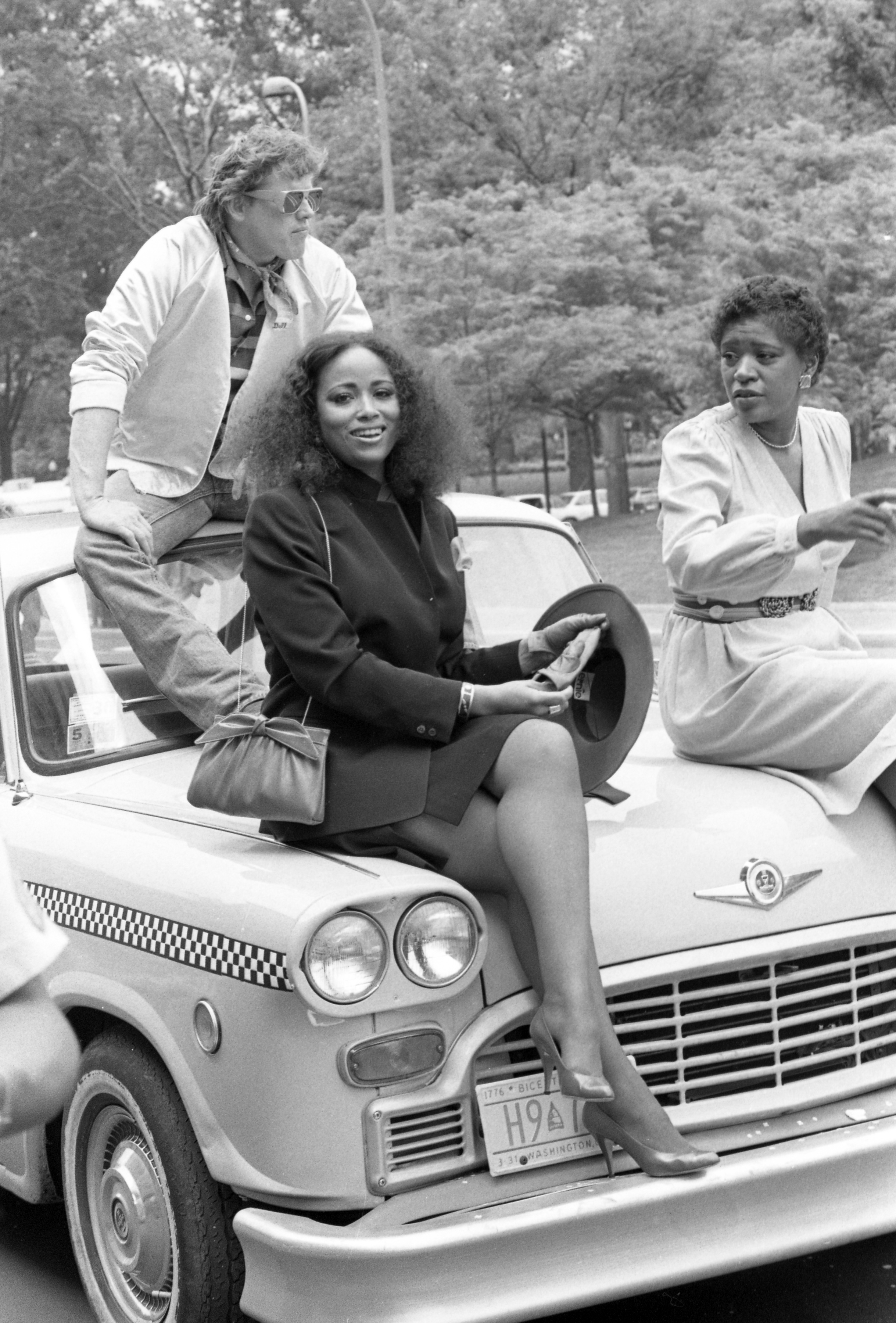 Gary Busey with Denise Gordy and Marsha Warfield on the set of the film "DC Cab" in 1983. | Source: Getty Images