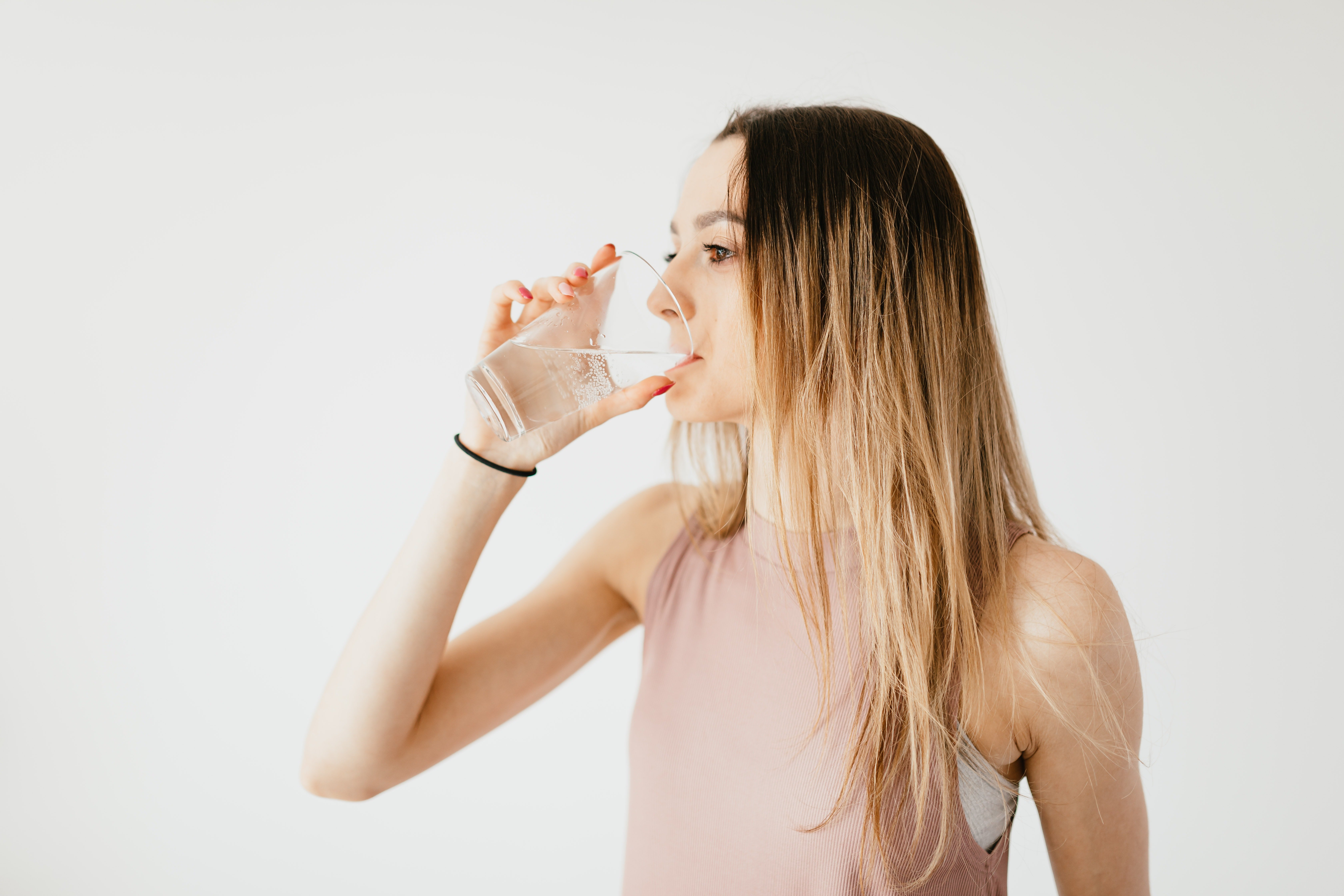 A woman drinking a glass of water | Source: Pexels