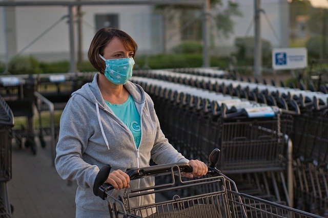 Mujer con mascarilla empujando un carrito de supermercado. | Foto: Pixabay