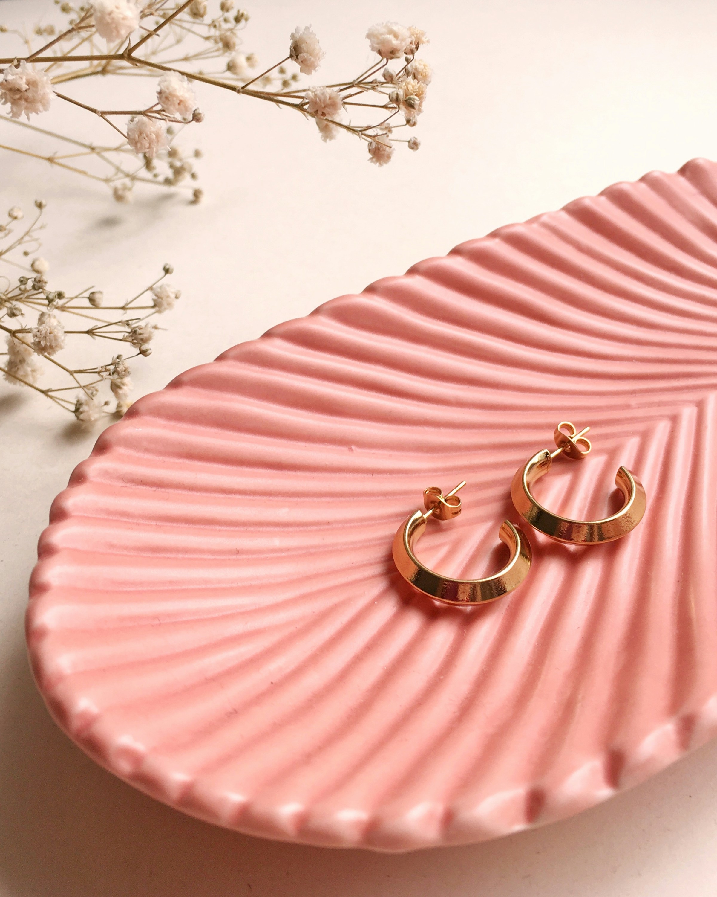 A pair of earrings on a pink tray | Source: Unsplash