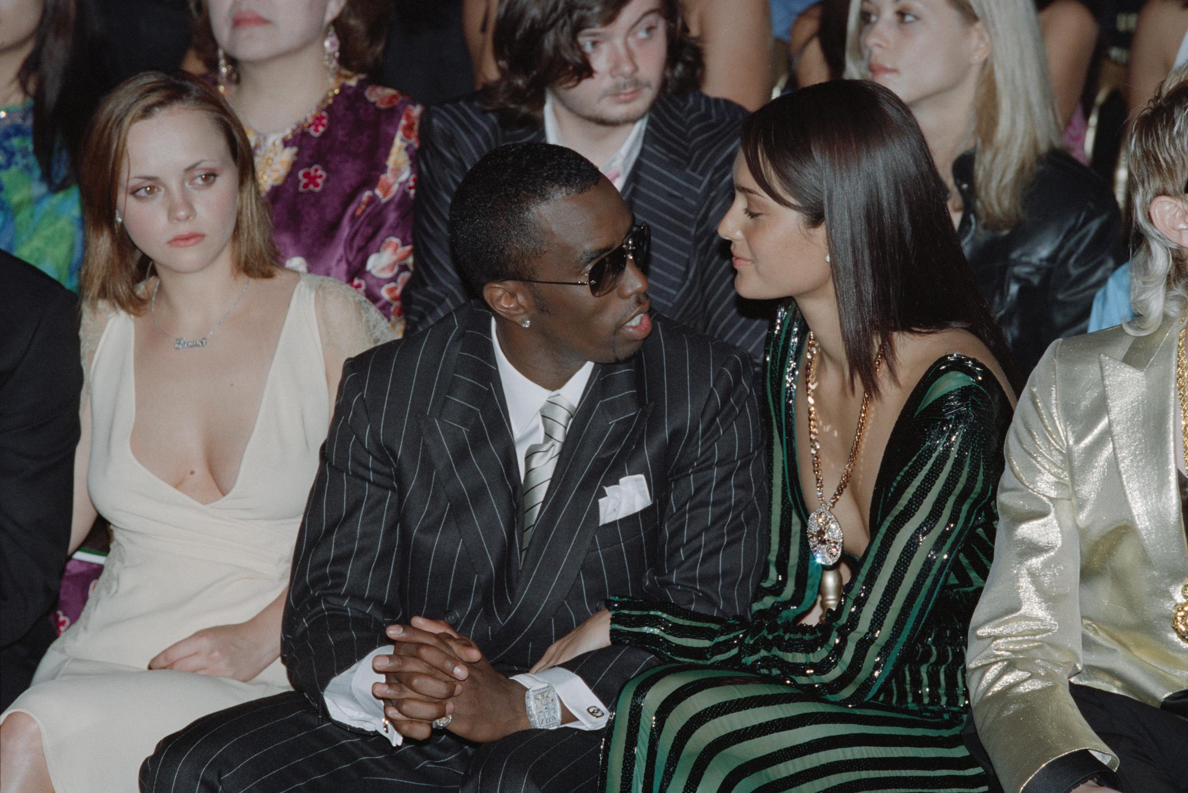 Emma Heming and P. Diddy sitting at the front row during Autumn-Winter Versace fashion show in Paris on July 7, 2001 | Source: Getty Images
