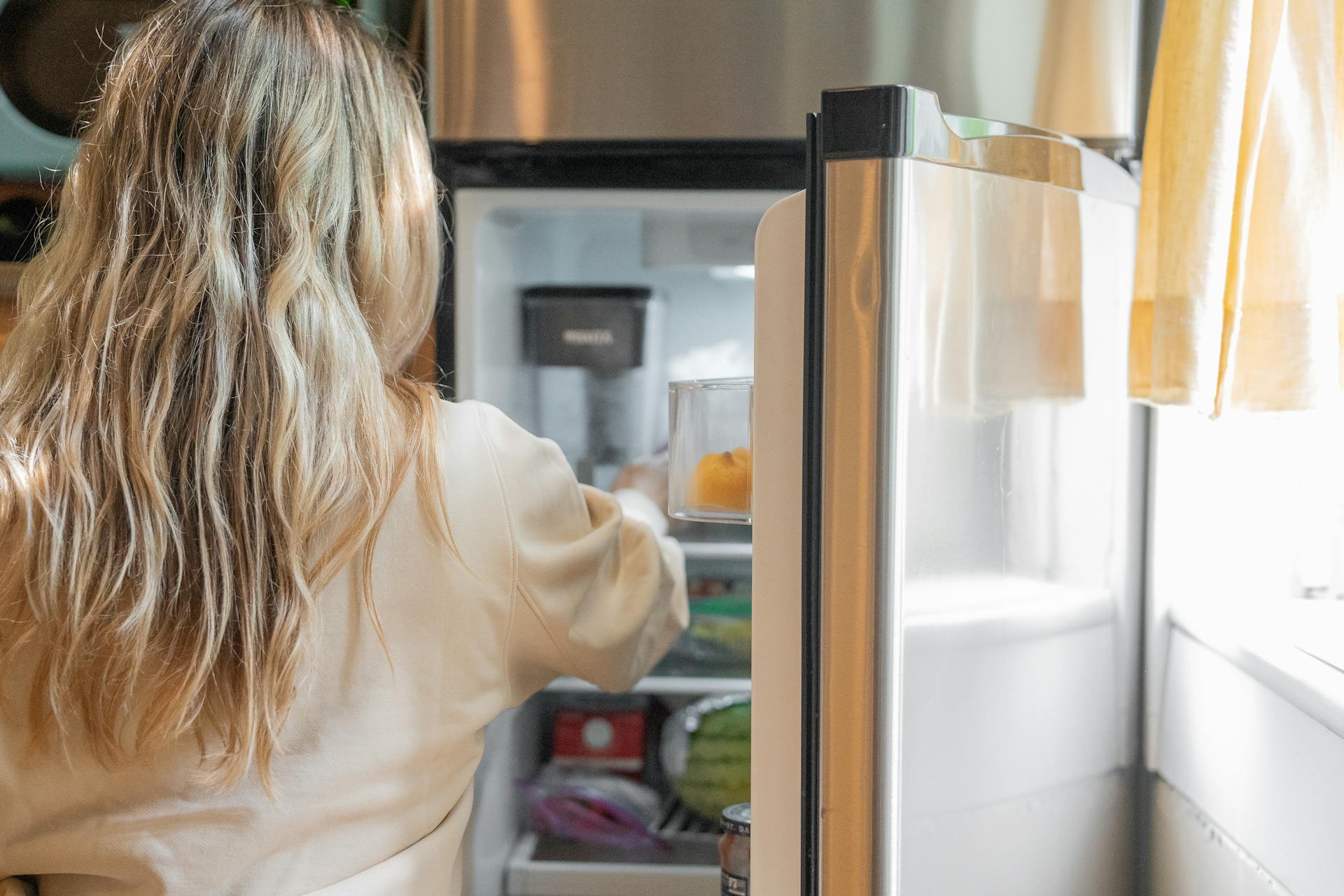 A woman standing near a fridge | Source: Pexels