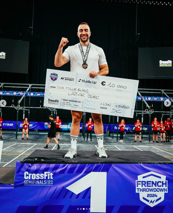 Lazar Dukic posing with a giant check at an event, posted on May 21, 2024 | Source: Instagram/crossfitgames, frenchthrowdown and lazadjukic