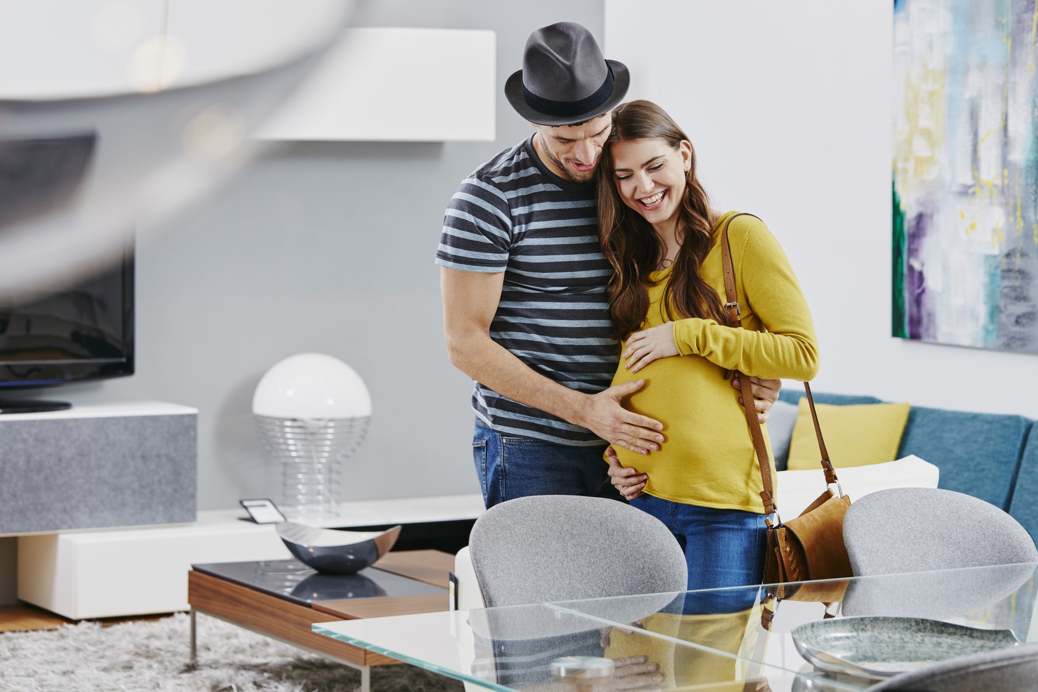 Photo of couple with pregnant woman in furniture store | Photo: Getty Images