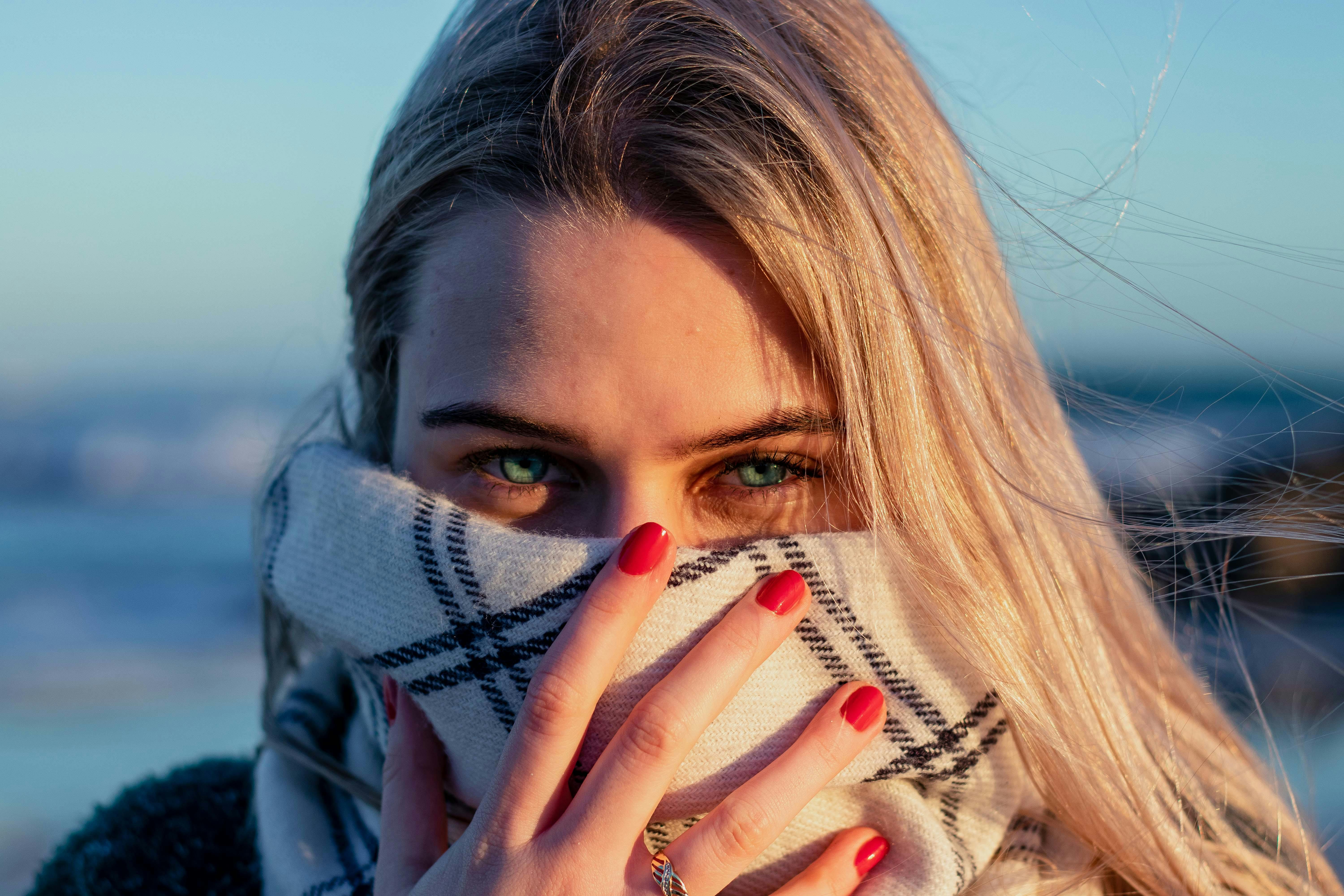 A person covering her face with a scarf. | Source: Pexels