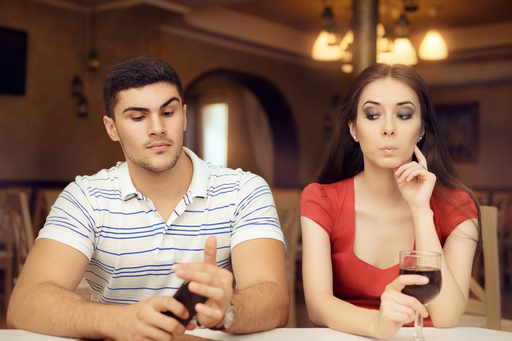 Man guarding his phone from partner | Photo: Shutterstock