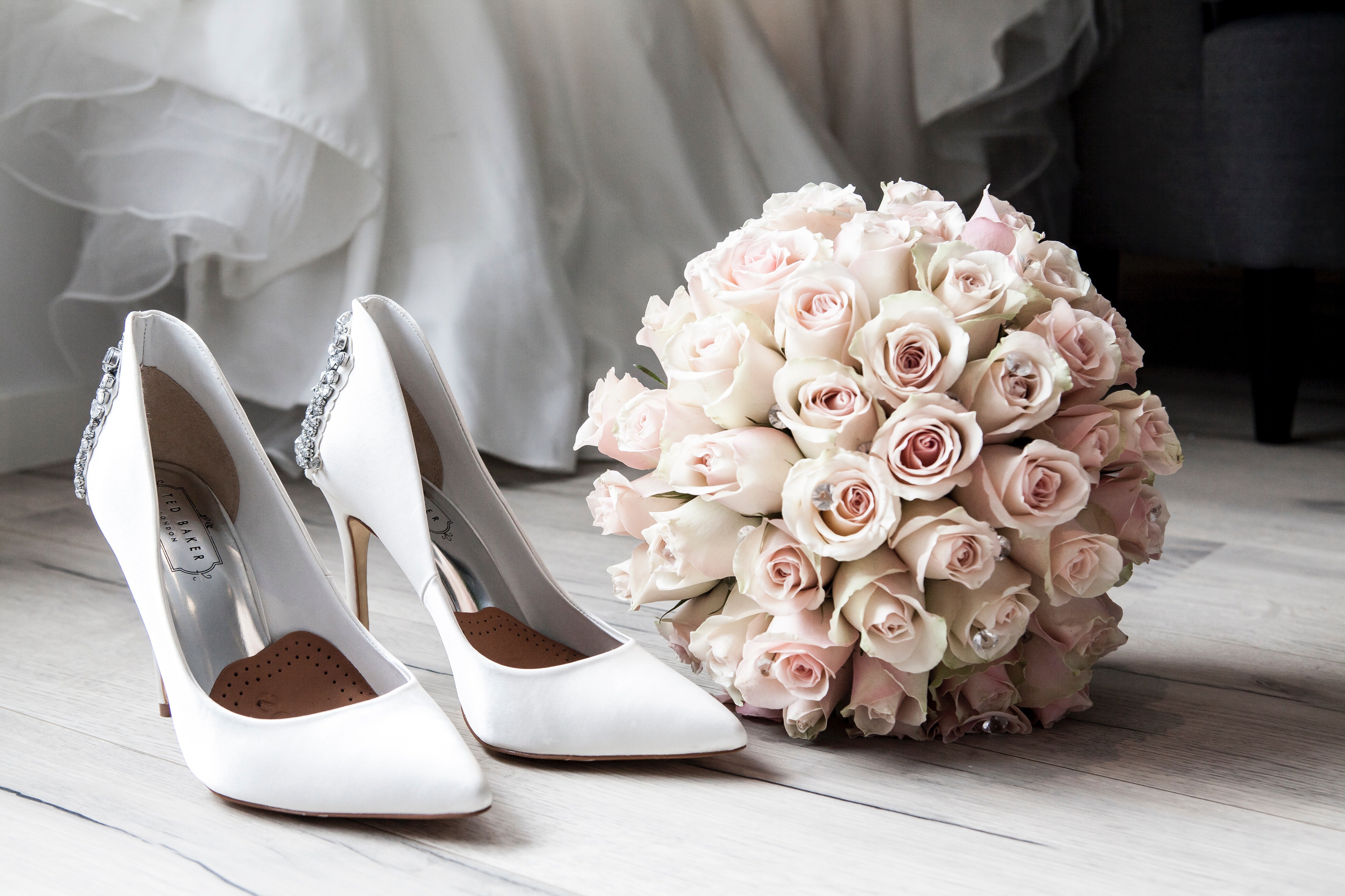 Un arreglo floral y un par de zapatos blancos. | Foto: Pexels