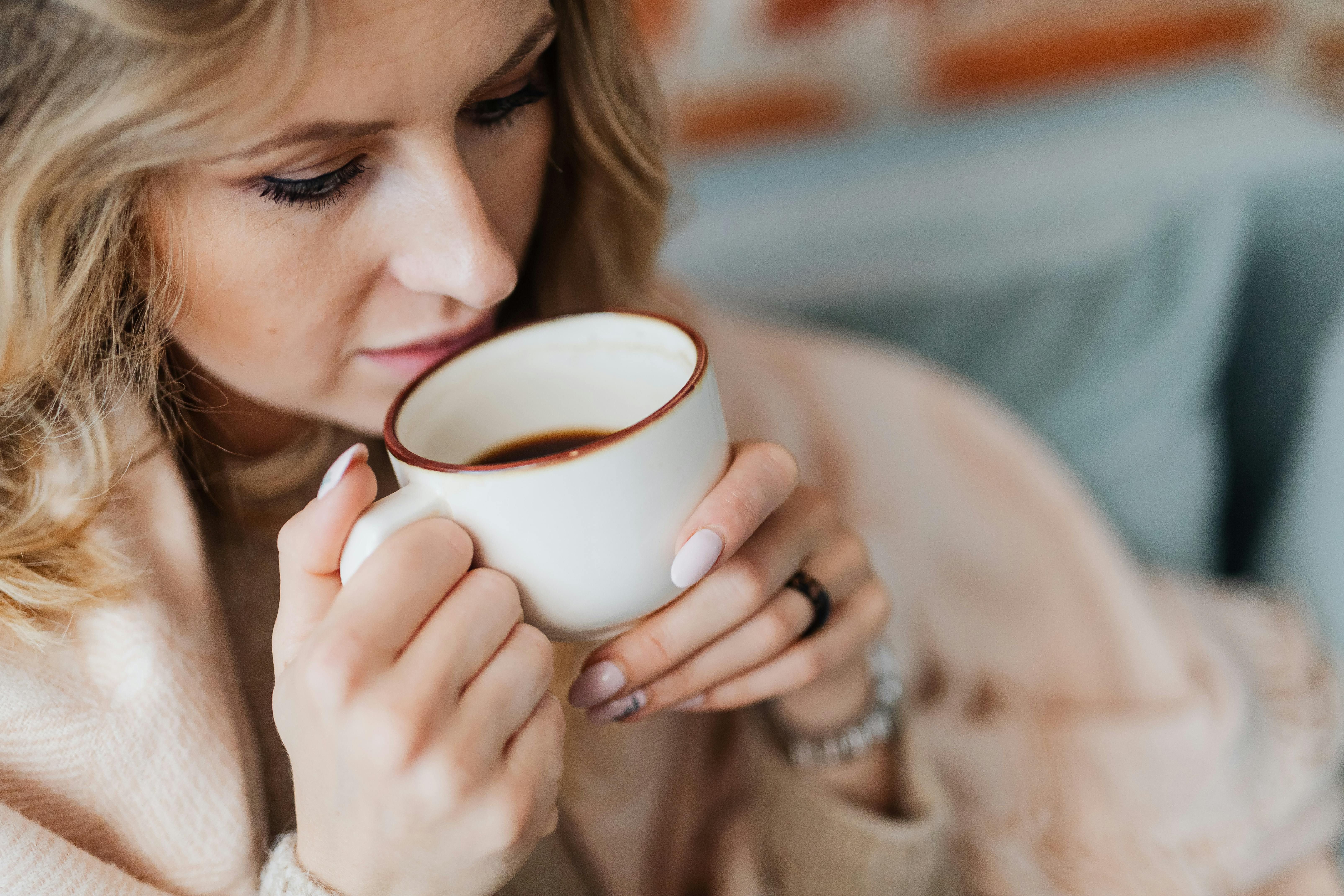 A woman about to take a sip of her coffee | Source: Pexels