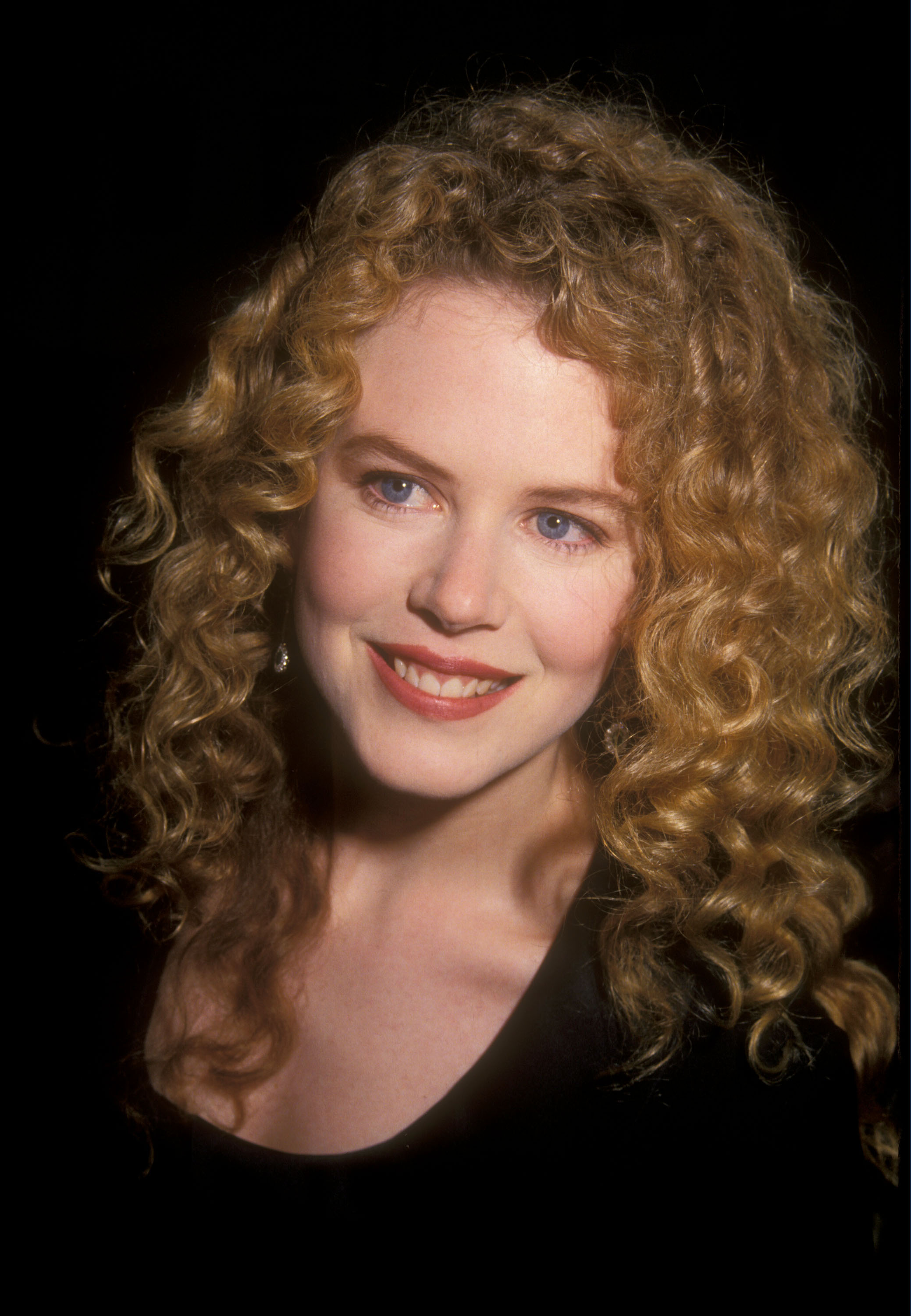 Nicole Kidman with brushed-out copper curls at the "Far and Away" premiere in Beverly Hills. Her hair is voluminous and parted to the side, with defined texture from root to tip.