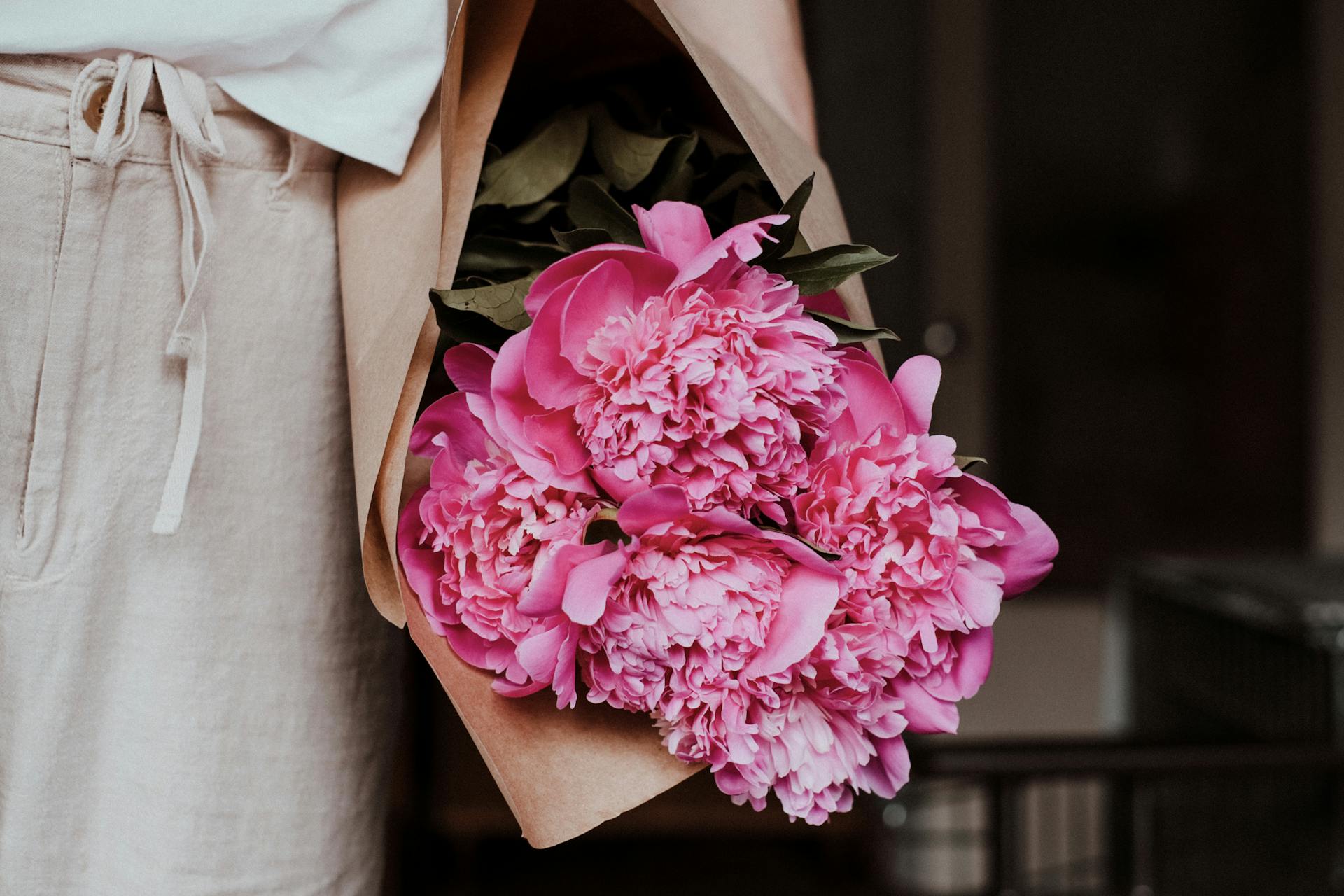 A woman holding a peony bouquet | Source: Pexels