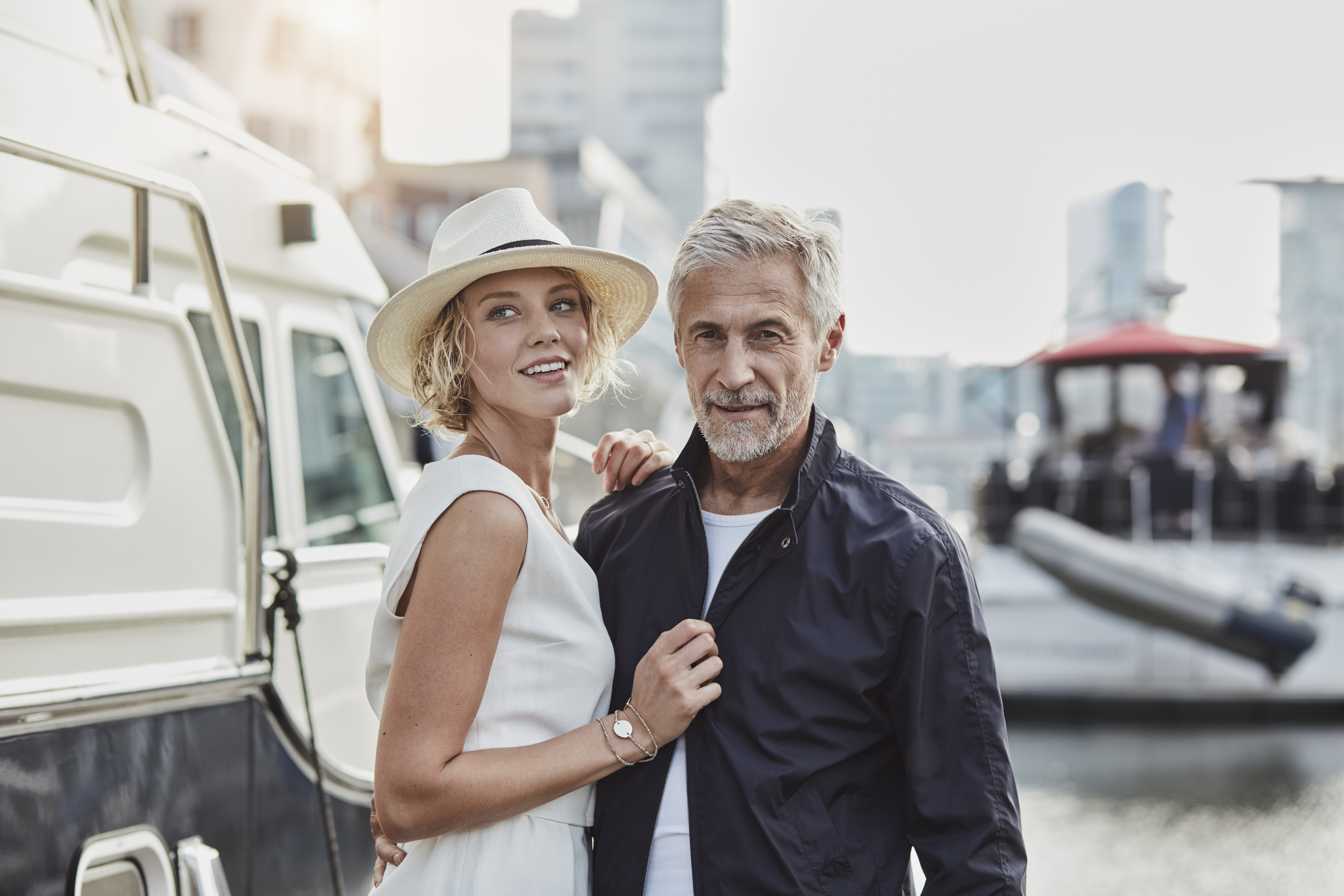 Older man and young woman at a marina next to a yacht | Source: Getty Images