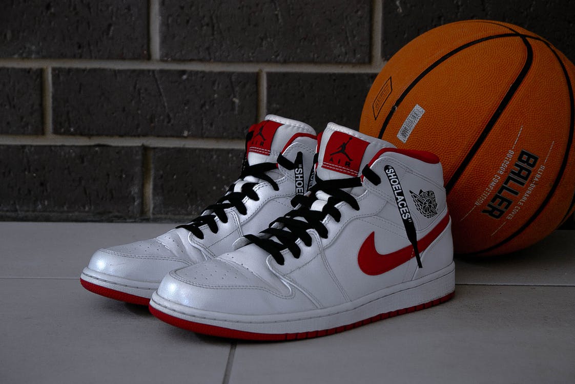 Unos zapatos deportivos junto a un balón de baloncesto. | Foto: Pexels