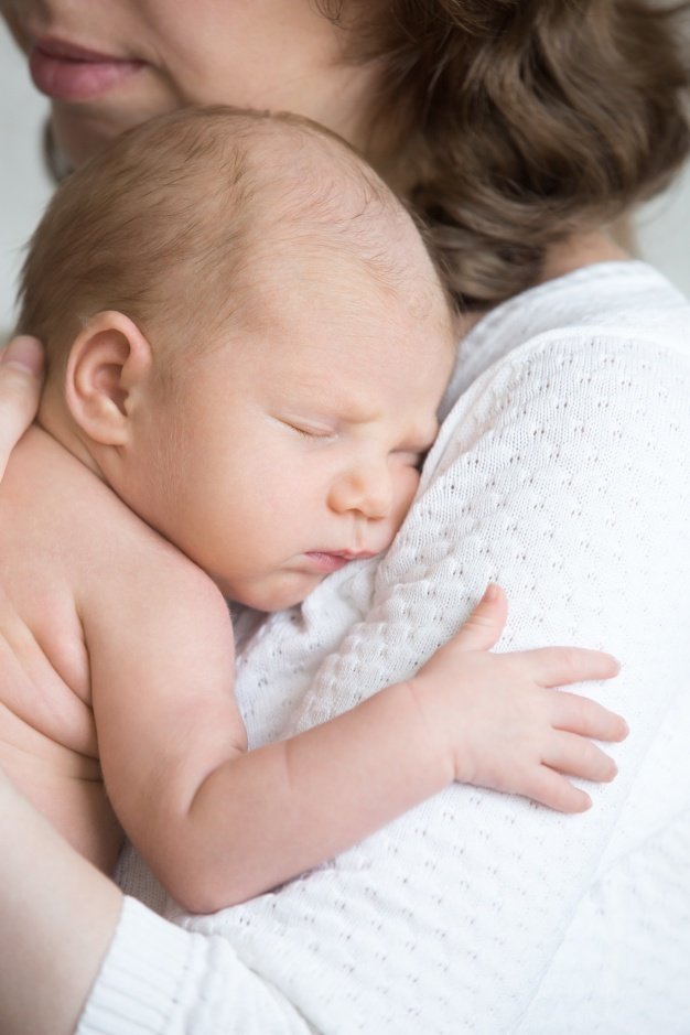 A young woman holding a baby | Source: Freepik