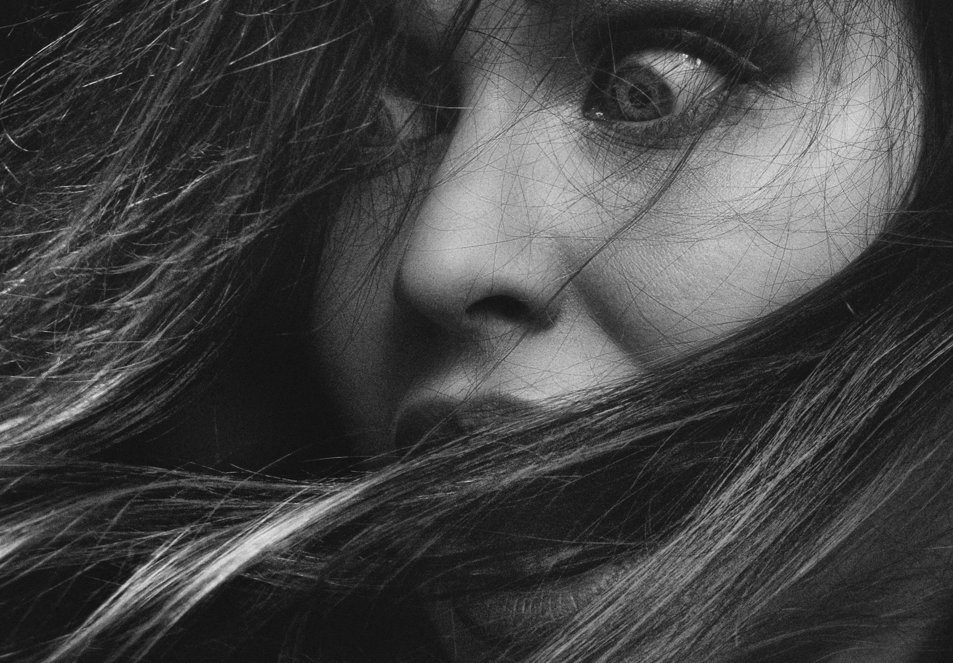 Grayscale portrait of a shocked woman with messy hair | Source: Pexels