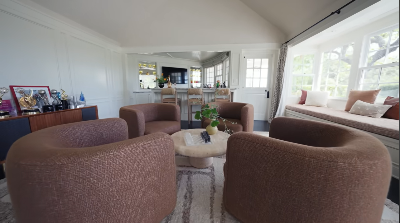 The ultimate hangout hub! Four stylish brown tub chairs create a tight conversational circle right in the center of the house. | Source: YouTube/@Archdigest