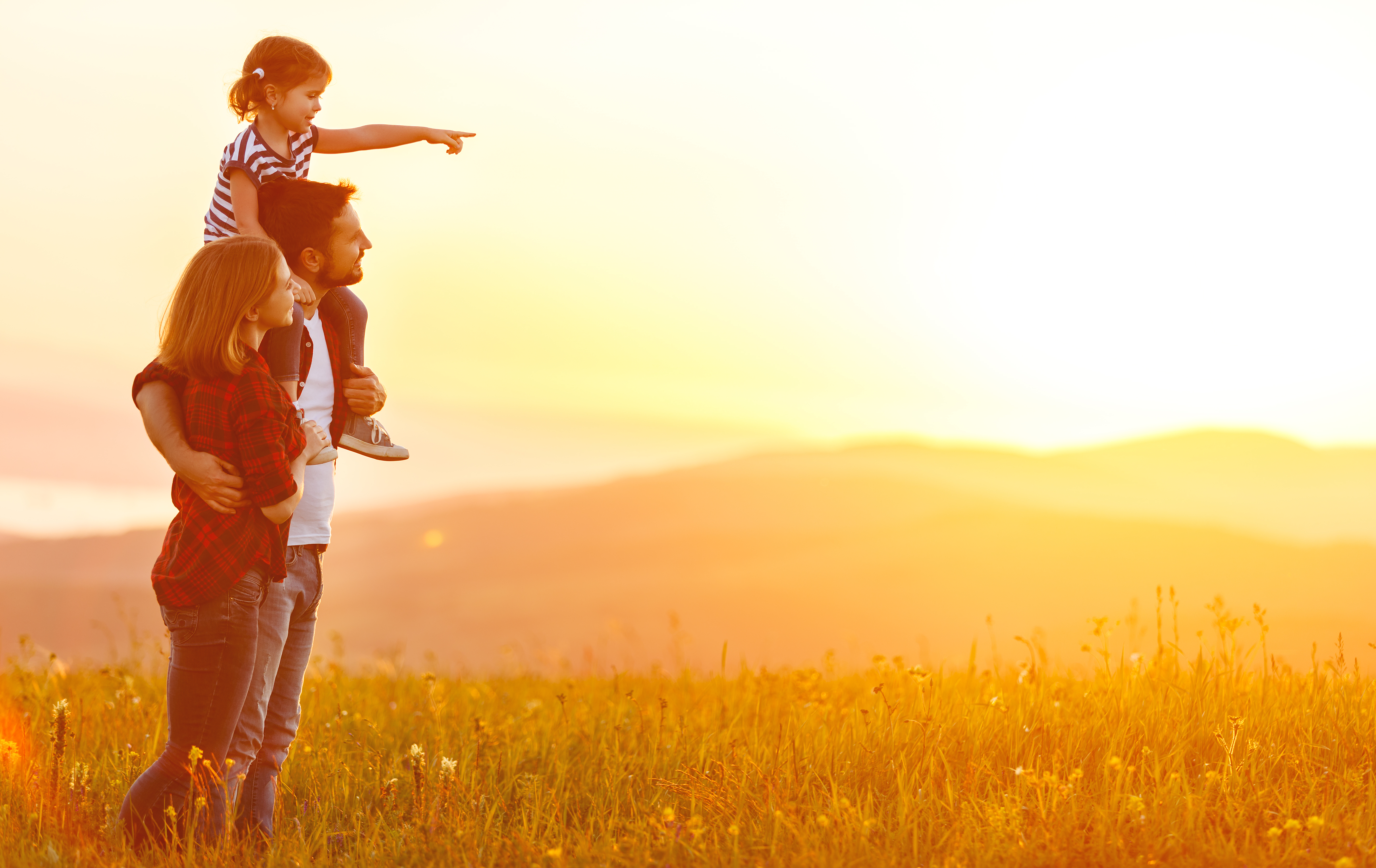 Couple watching the sunset with their little daughter | Source: Shutterstock
