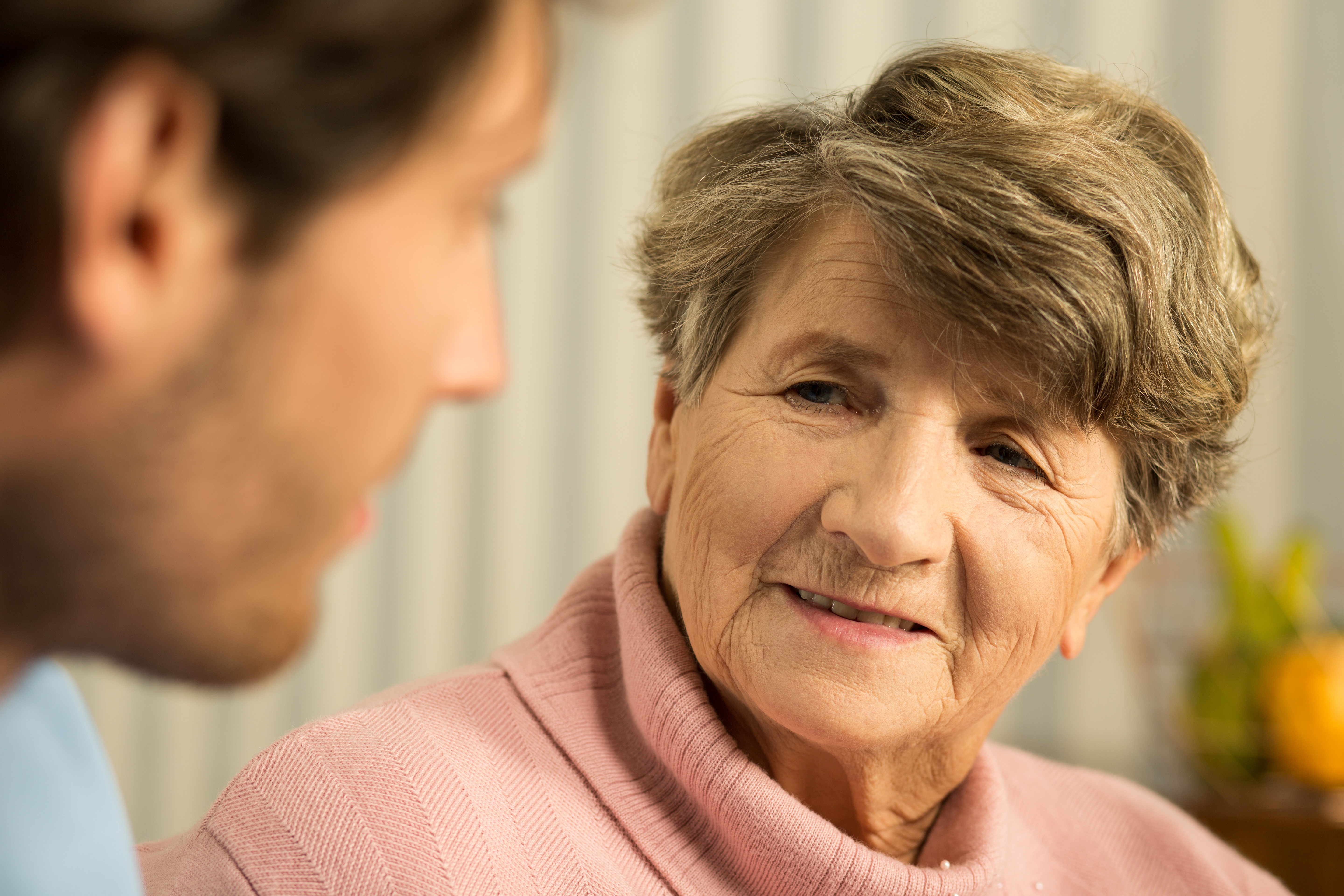 A  senior woman talking with a young man | Source: Shutterstock