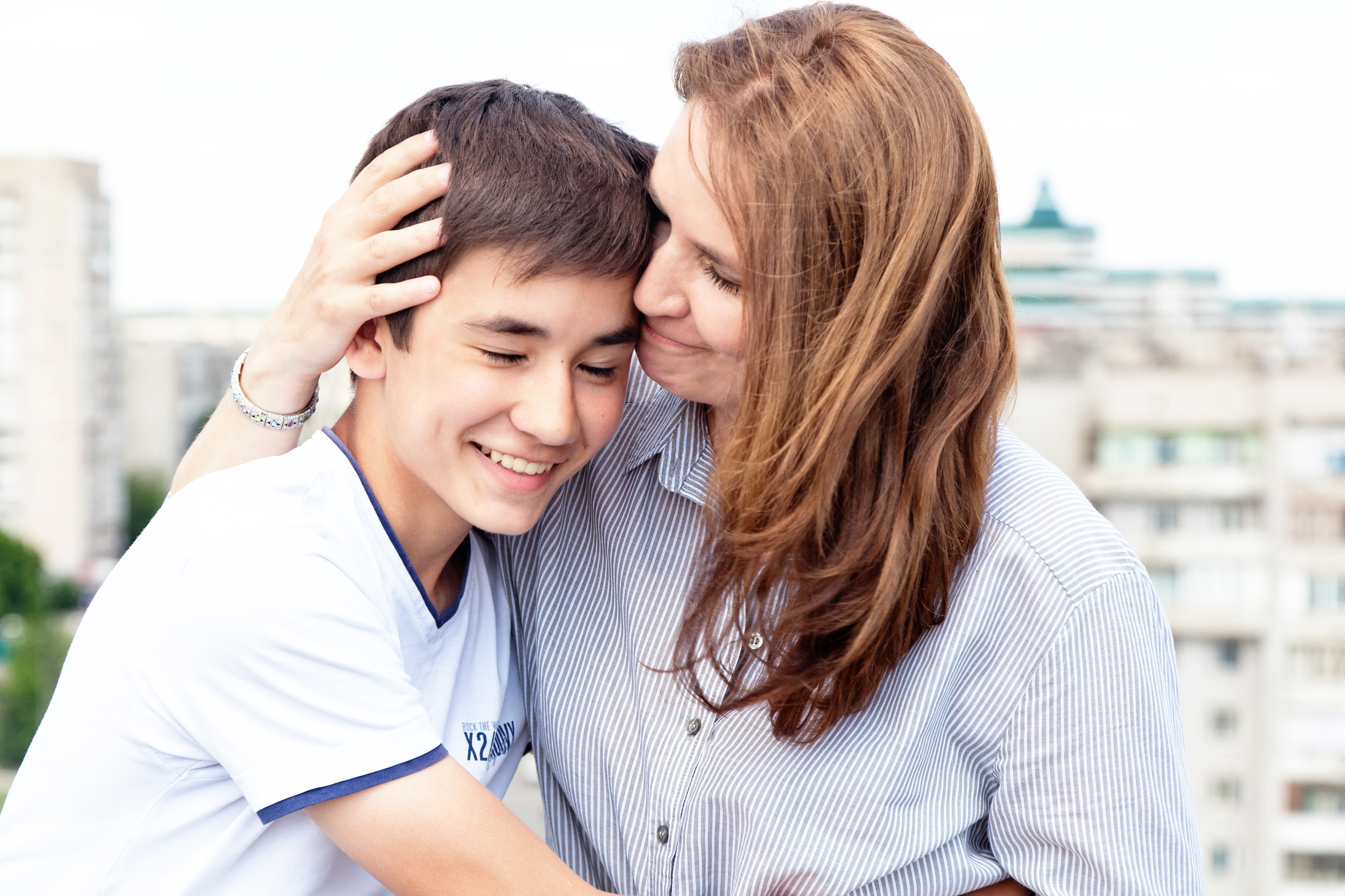Mother hugging her teenage son | Source: Shutterstock