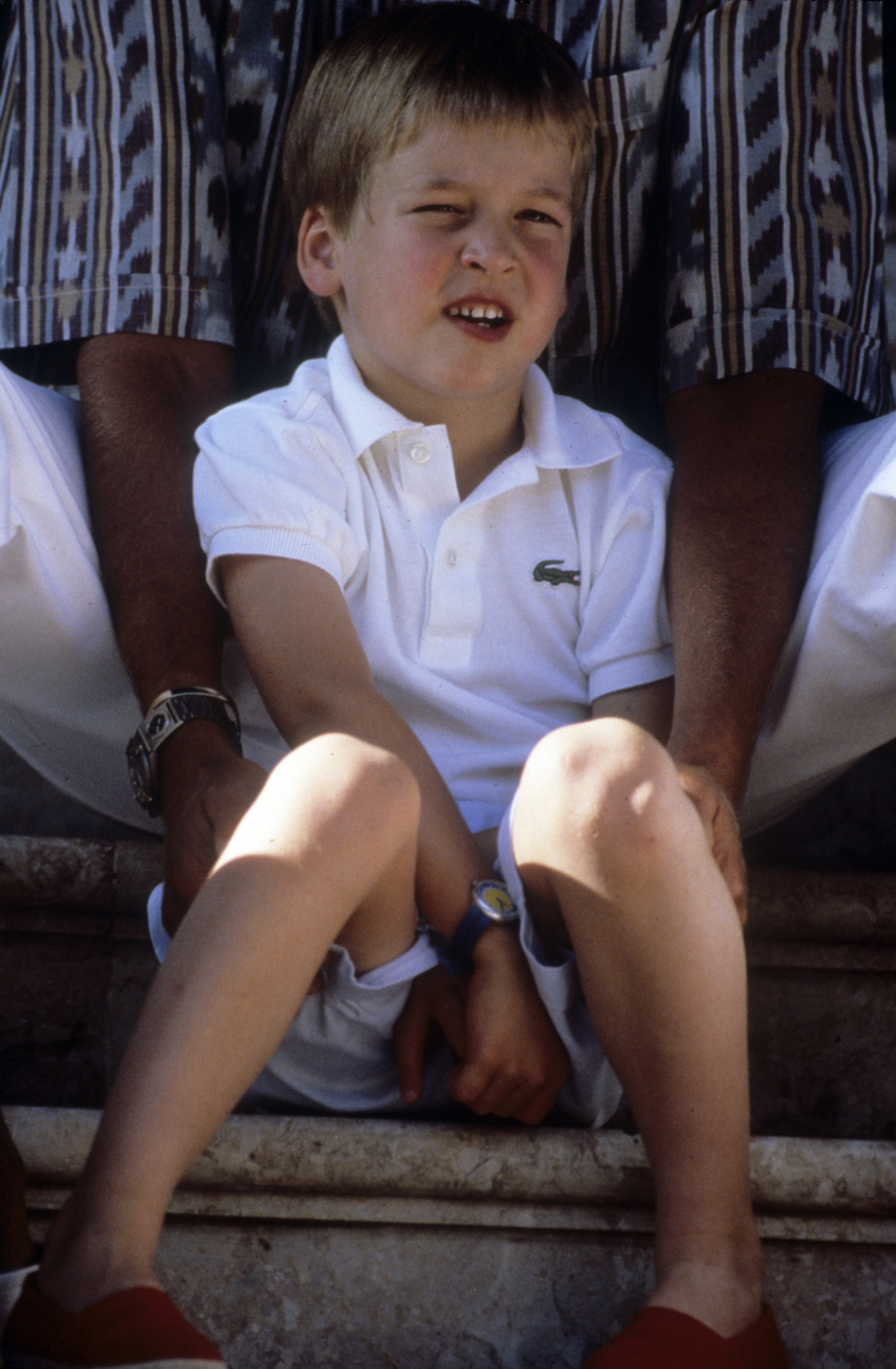 Prince William sits with King Juan Carlos during a summer holiday in Majorca on August 13, 1988, in Palma, Spain. | Source: Getty Images.