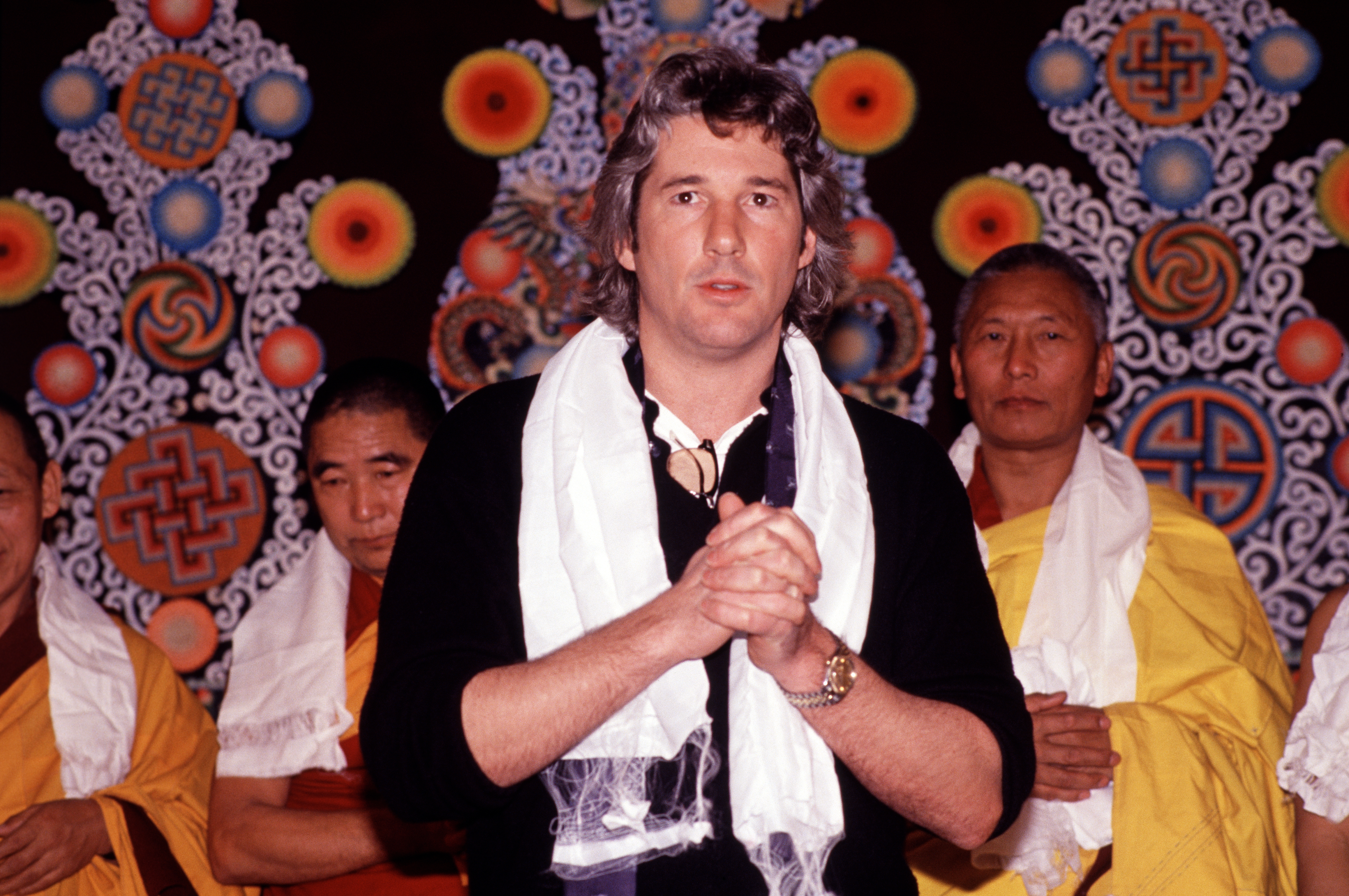 Richard Gere and Indian monks during a demonstration of butter sculptures held at the American Museum of Natural History on February 24, 1989 in New York. | Source: Getty Images