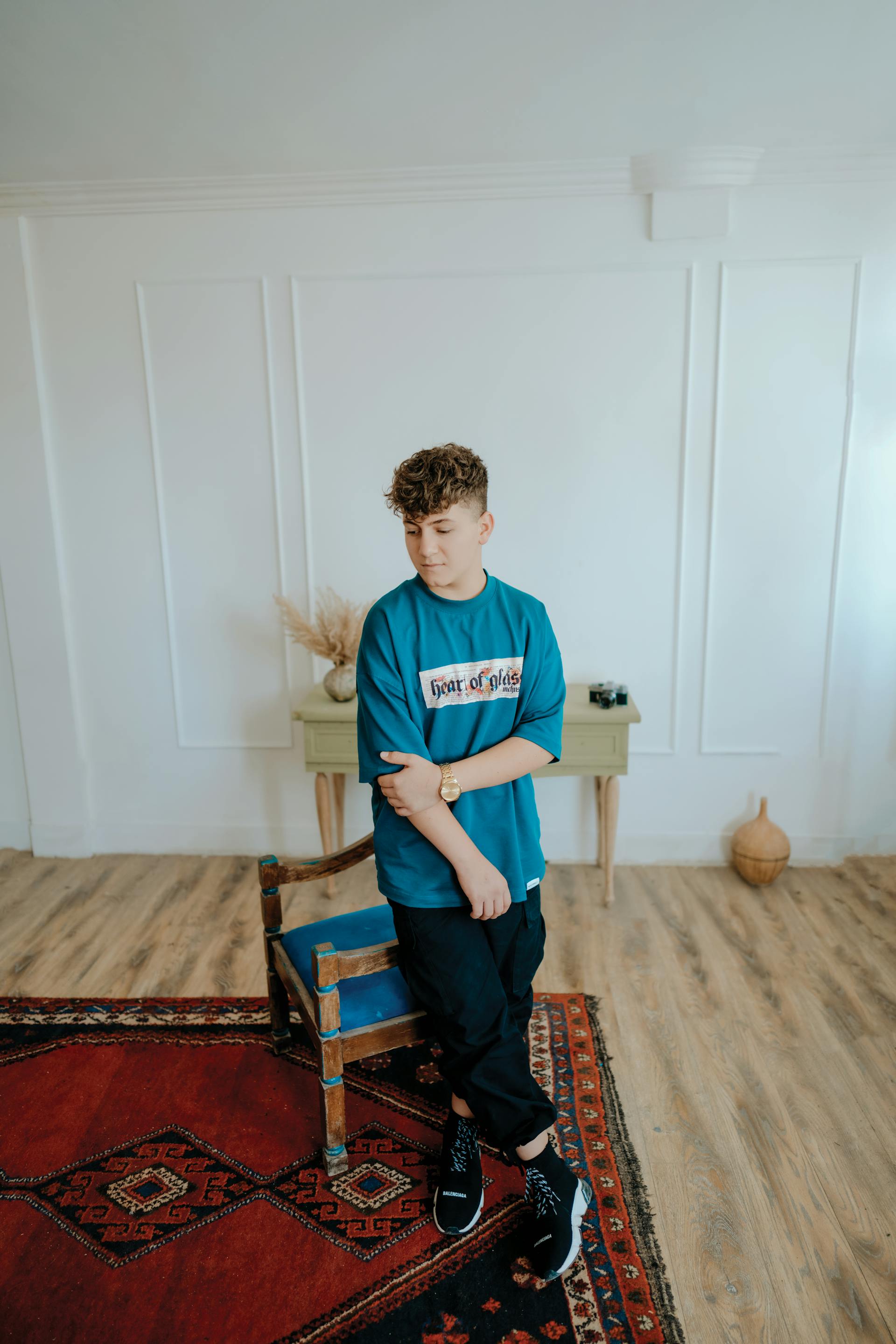 A teenage boy leaning against a chair | Source: Pexels