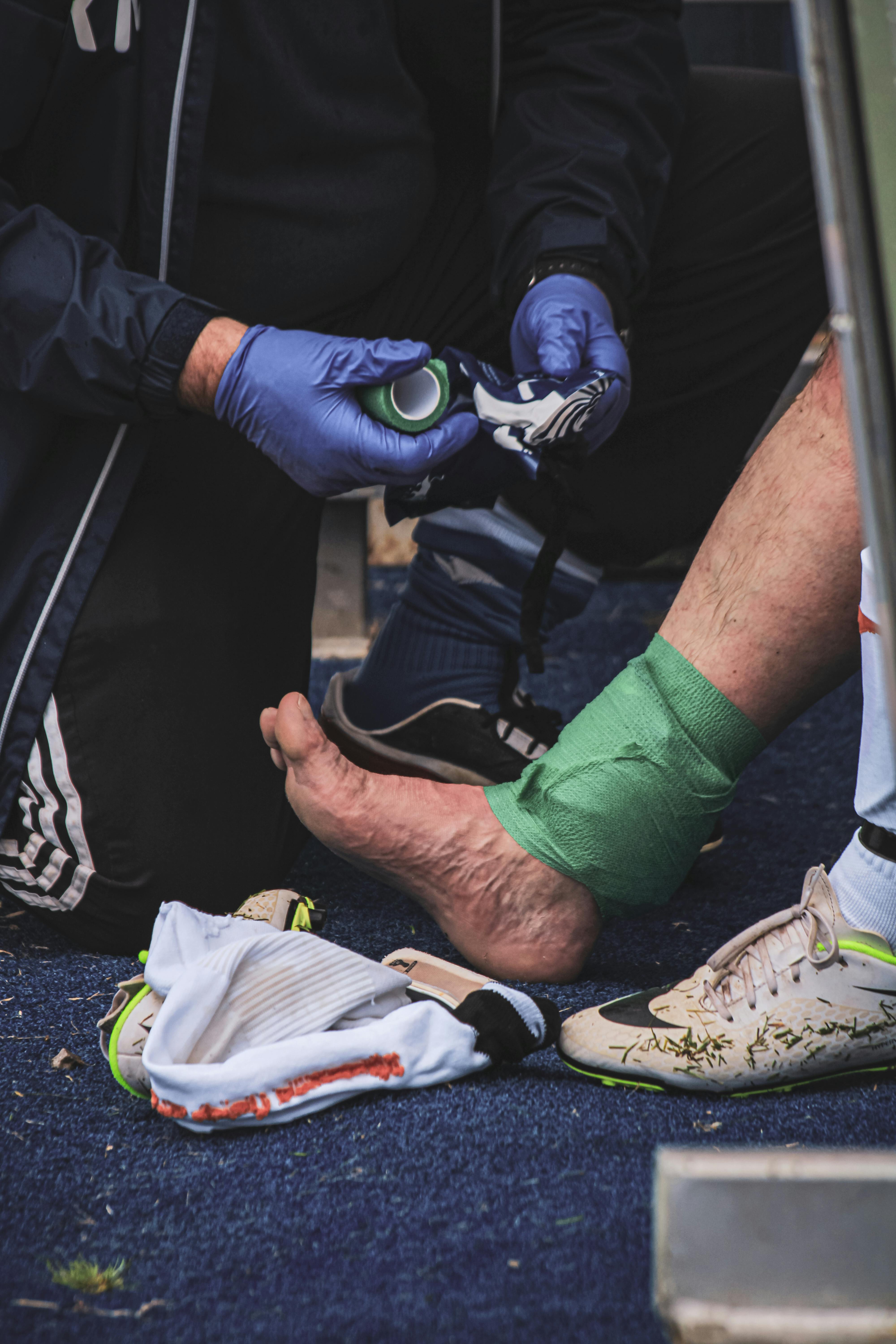 A man helping a player with an injury. | Source: Pexels