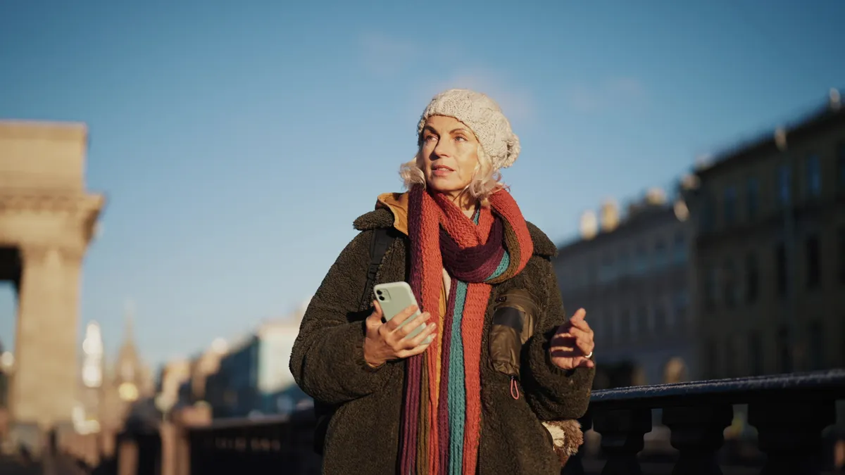 A solo traveler using her phone | Source: Shutterstock
