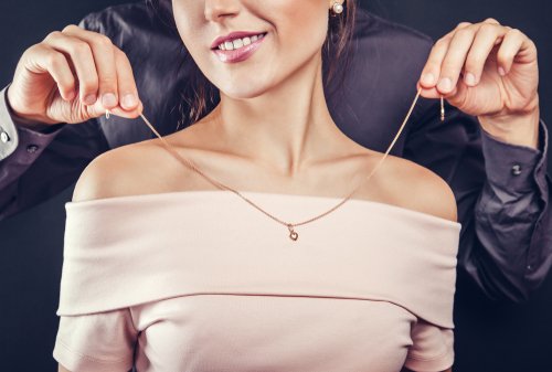 Mann legt Frau eine Halskette an | Quelle: Shutterstock