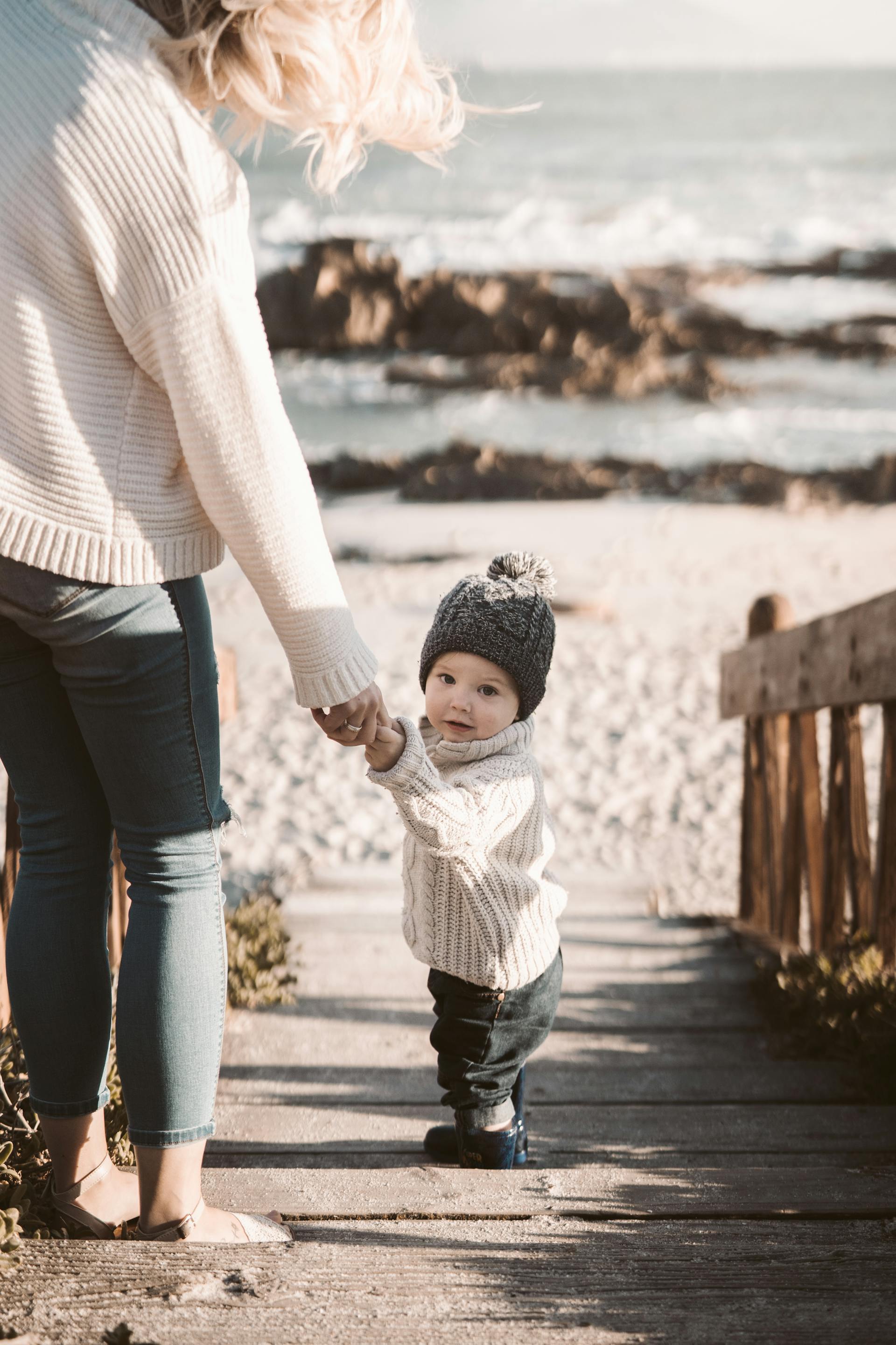A mother holding her toddler's hand | Source: Pexels