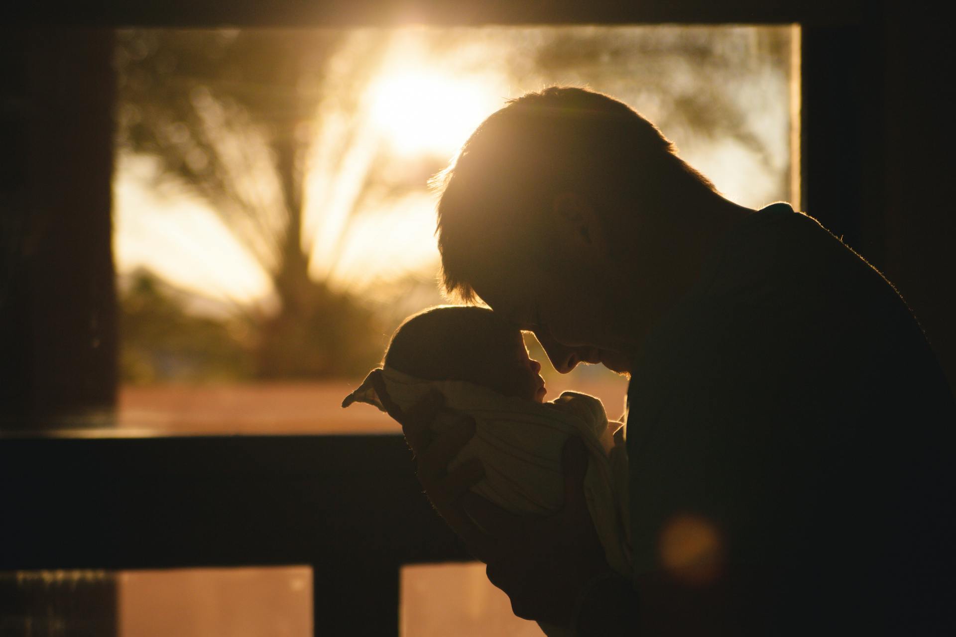 A father holding his newborn baby | Source: Pexels