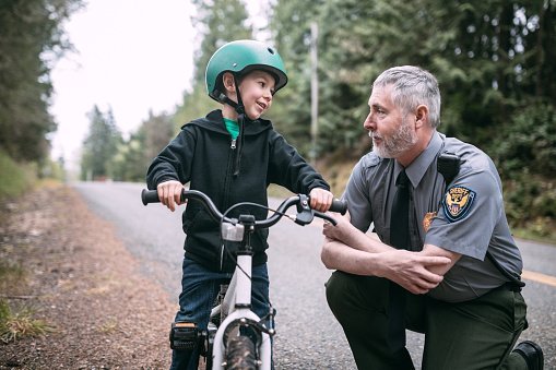 A policeman talking to a little boy.| Photo: Getty Images.