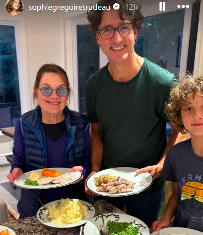 Justin Trudeau standing between two loved ones as the smiling family dishes delicious-looking food onto their plates. | Source: Instagram/sophiegregoiretrudeau