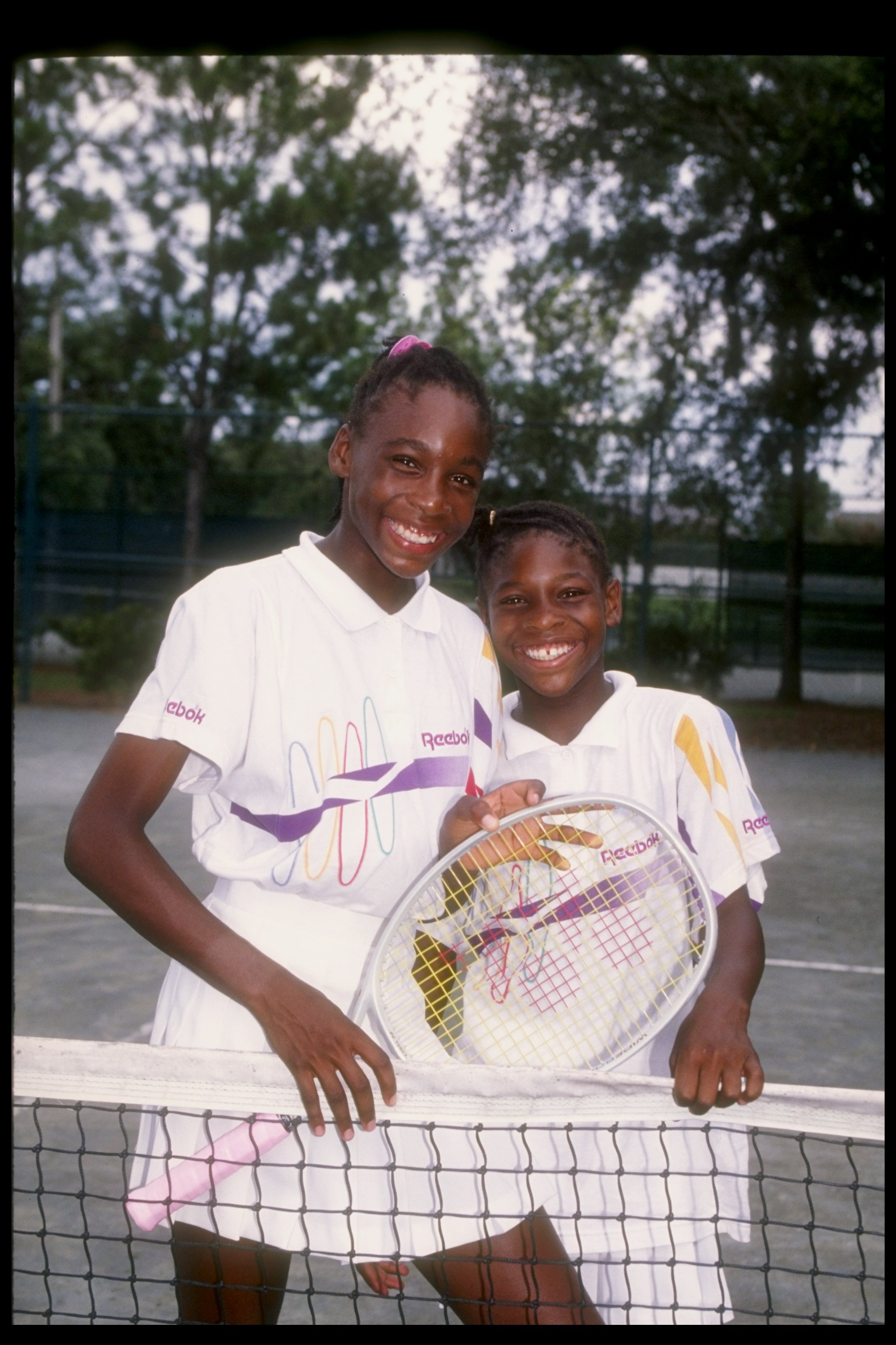 Venus and Serena Williams pose on a tennis court in Florida on July 22, 1992 | Source: Getty Images