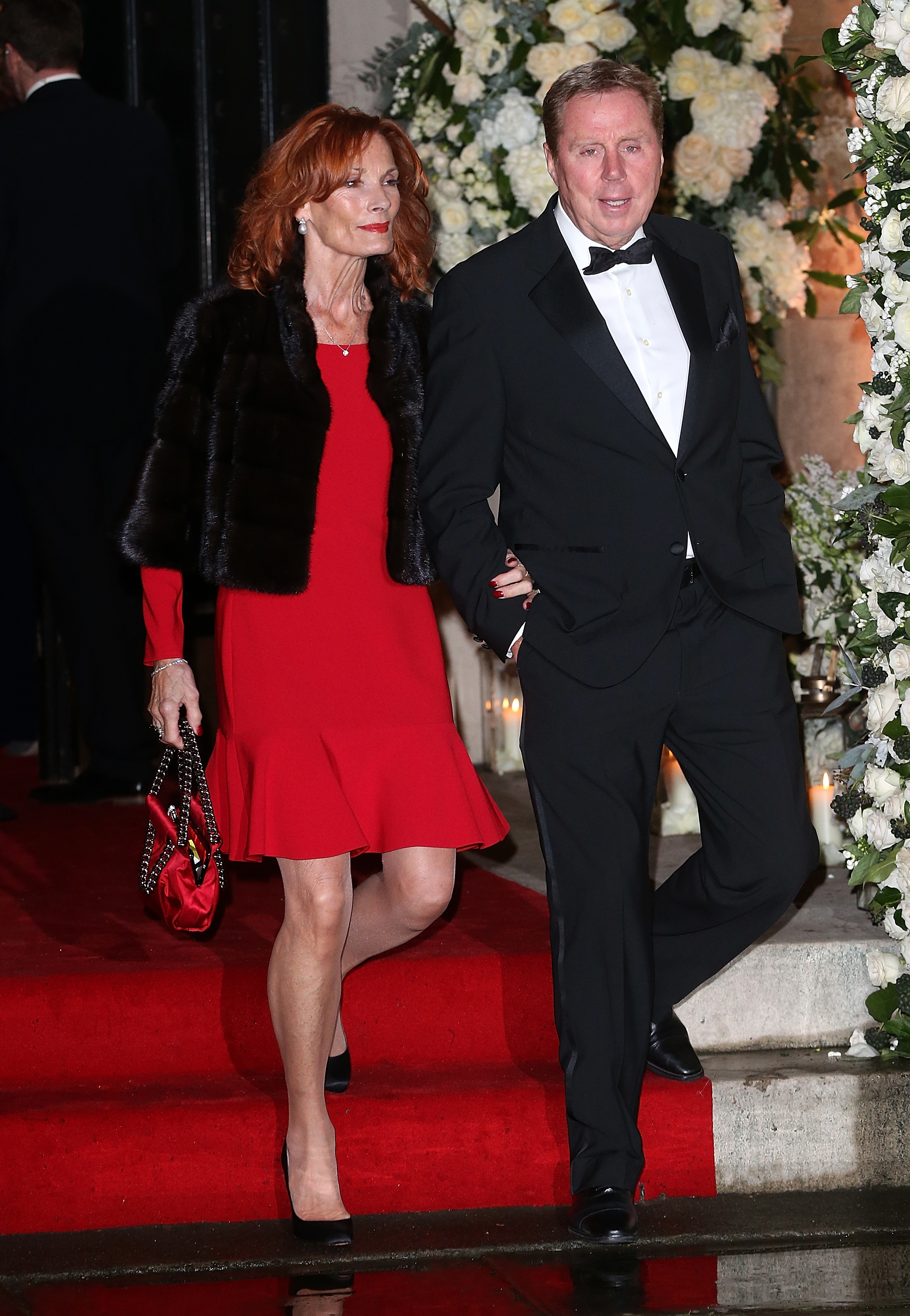 Sandra and Harry Redknapp stepped out in coordinated elegance at Frank Lampard and Christine Bleakley's wedding on 20 December 2015, with Sandra in a striking red dress and black fur stole while Harry wore a classic black tuxedo, the couple walking arm in arm as they arrived at the London ceremony.