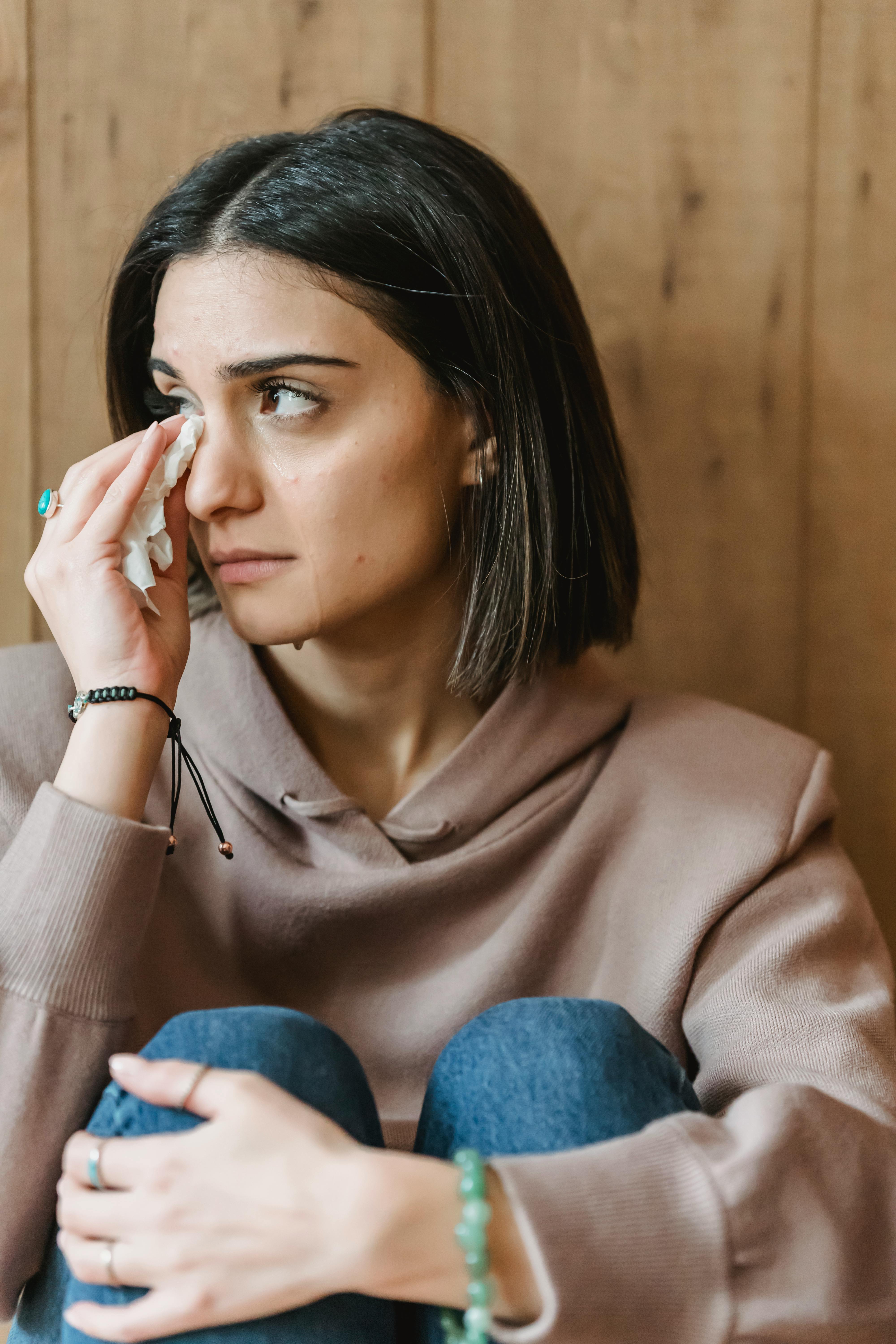 A woman wiping away her tears | Source: Pexels