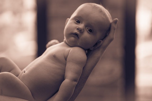 Un bébé dans les bras de sa mère. l Source: Flickr