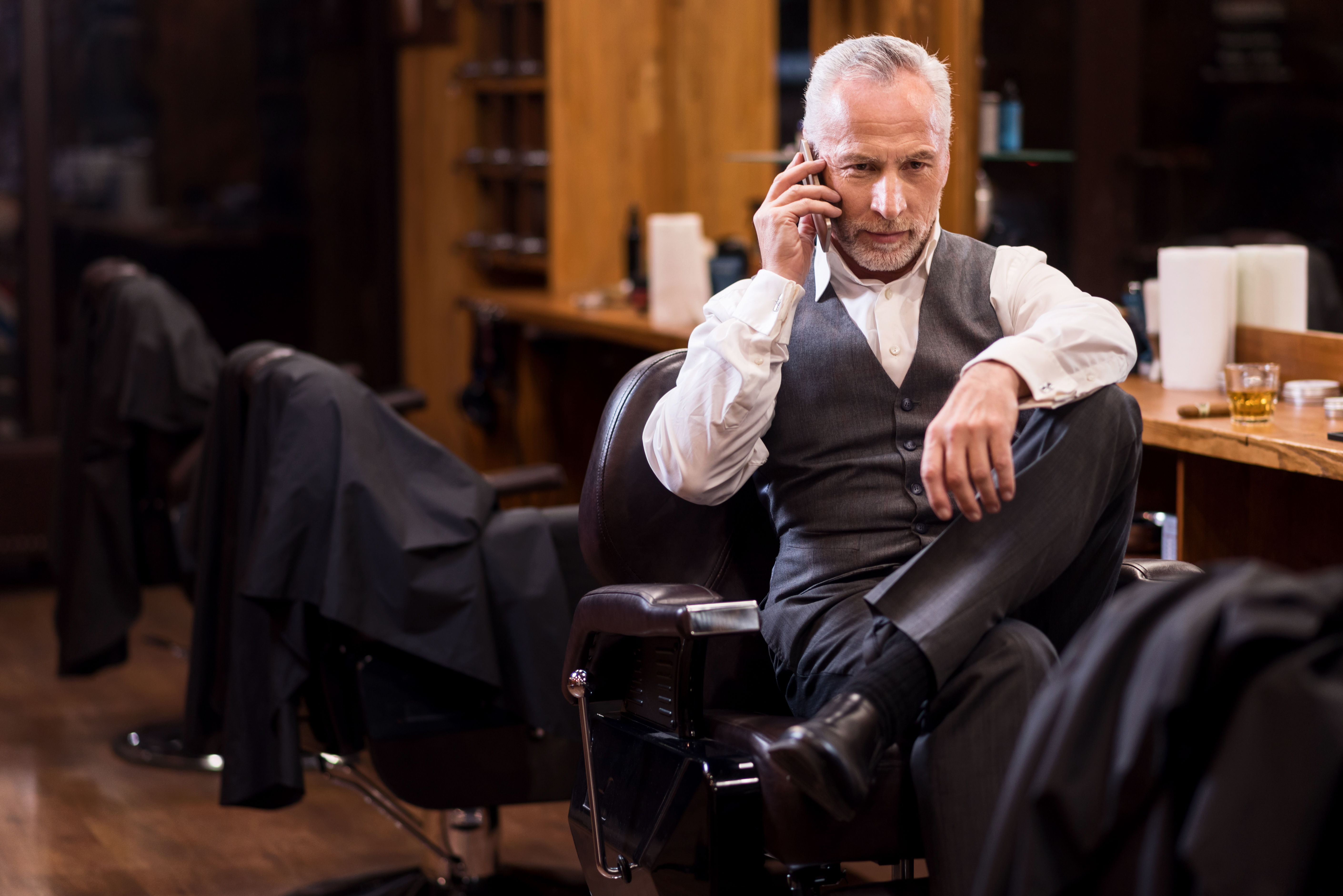 Business sitting man talking on mobile phone. | Source: Shutterstock