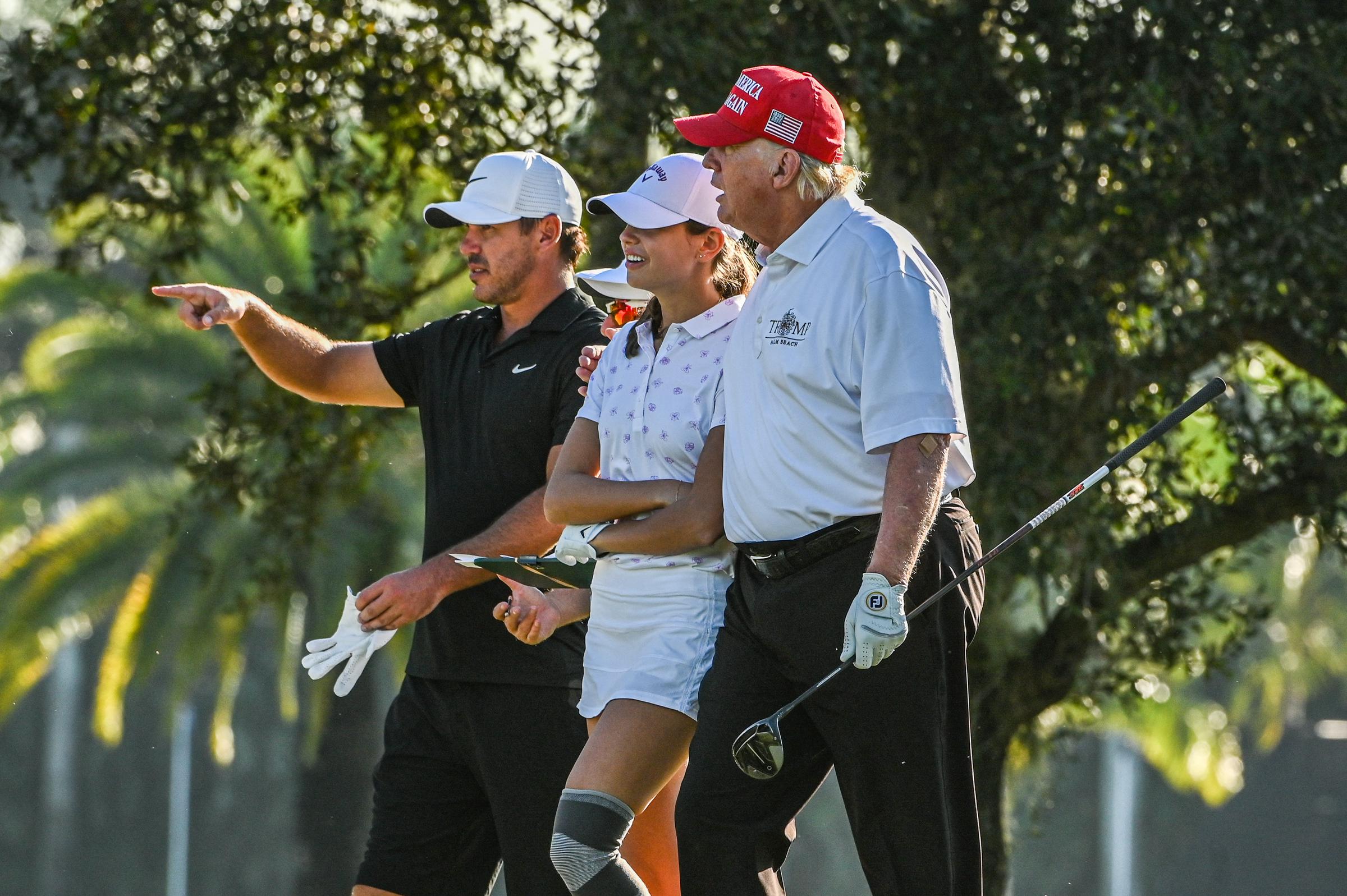 Donald Trump, US golfer Brooks Koepka and Trump's granddaughter Kai Trump play golf at Trump National Doral Miami golf club on October 27, 2022 in Miami, Florida | Source: Getty Images