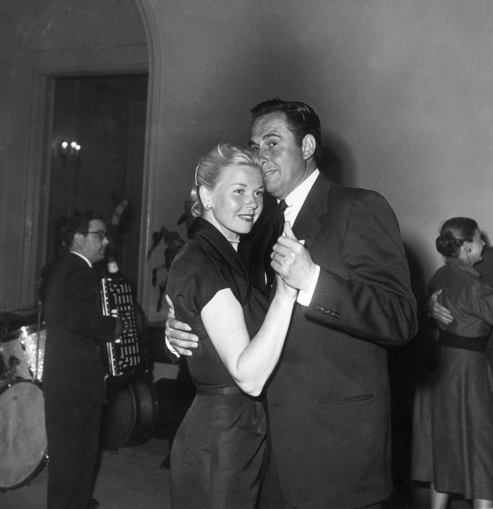 American actor and singer Doris Day dancing with her third husband, agent Marty Melcher, at a party circa 1955 | Source: Getty Images
