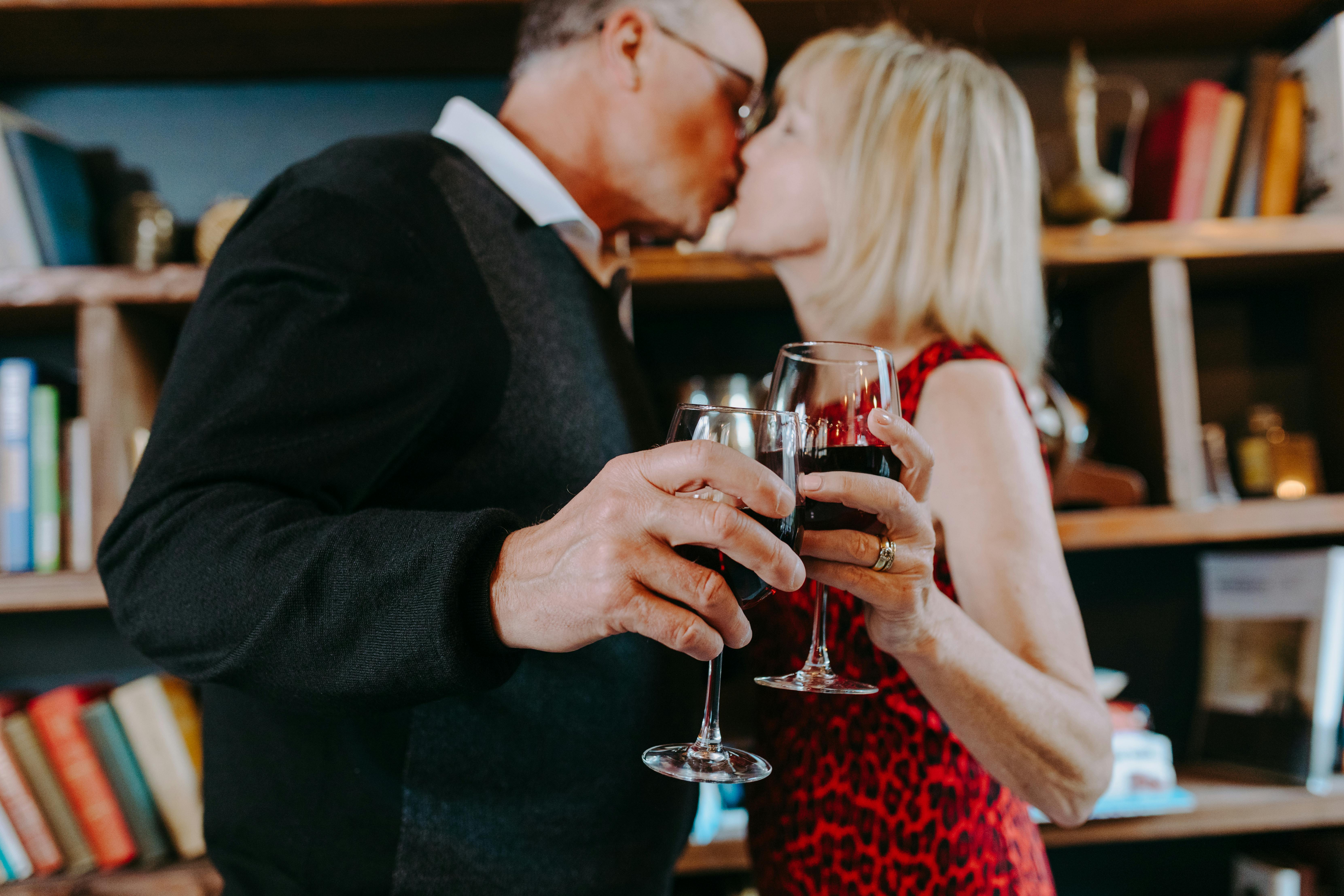 A couple sharing a toast and a kiss | Source: Pexels