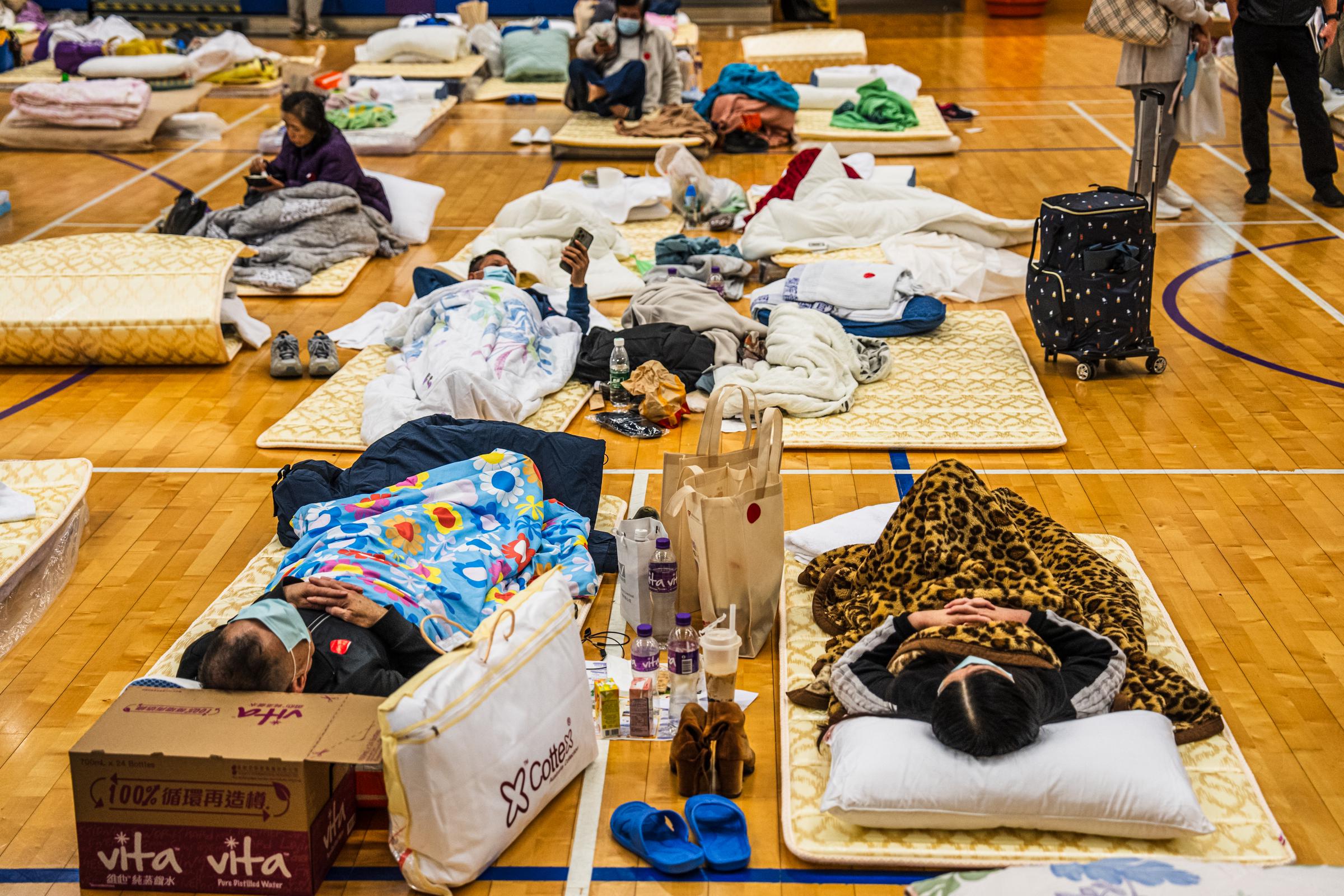 Residents impacted by the fire at the Wang Fuk Court rest at a temporary shelter in Tai Po district in Hong Kong, China, on November 27, 2025. | Source: Getty Images