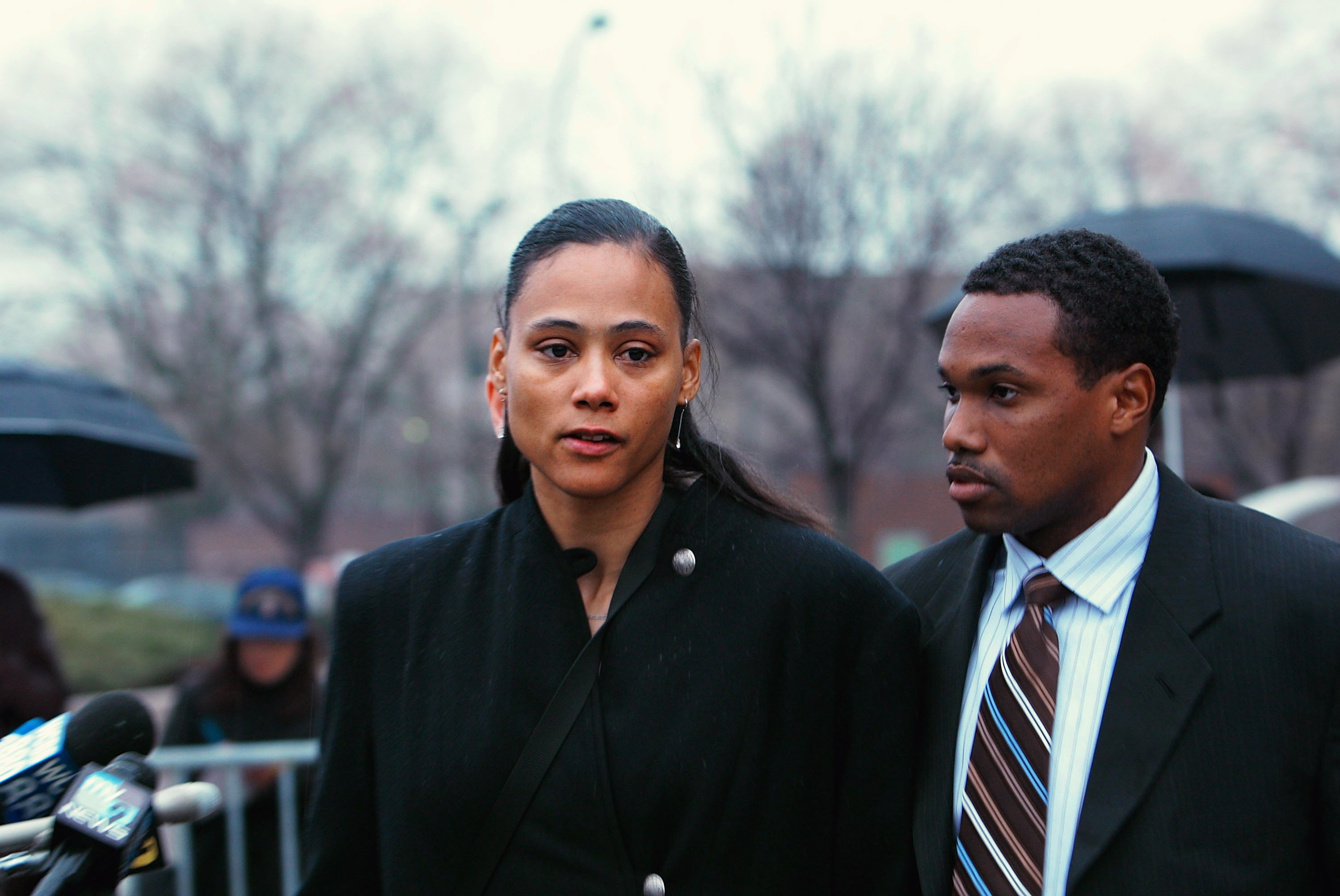 Marion Jones stands with her husband Obadele Thompson after she leaves court on January 11, 2008, in White Plains, New York | Photo: Chris Hondros/Getty Images