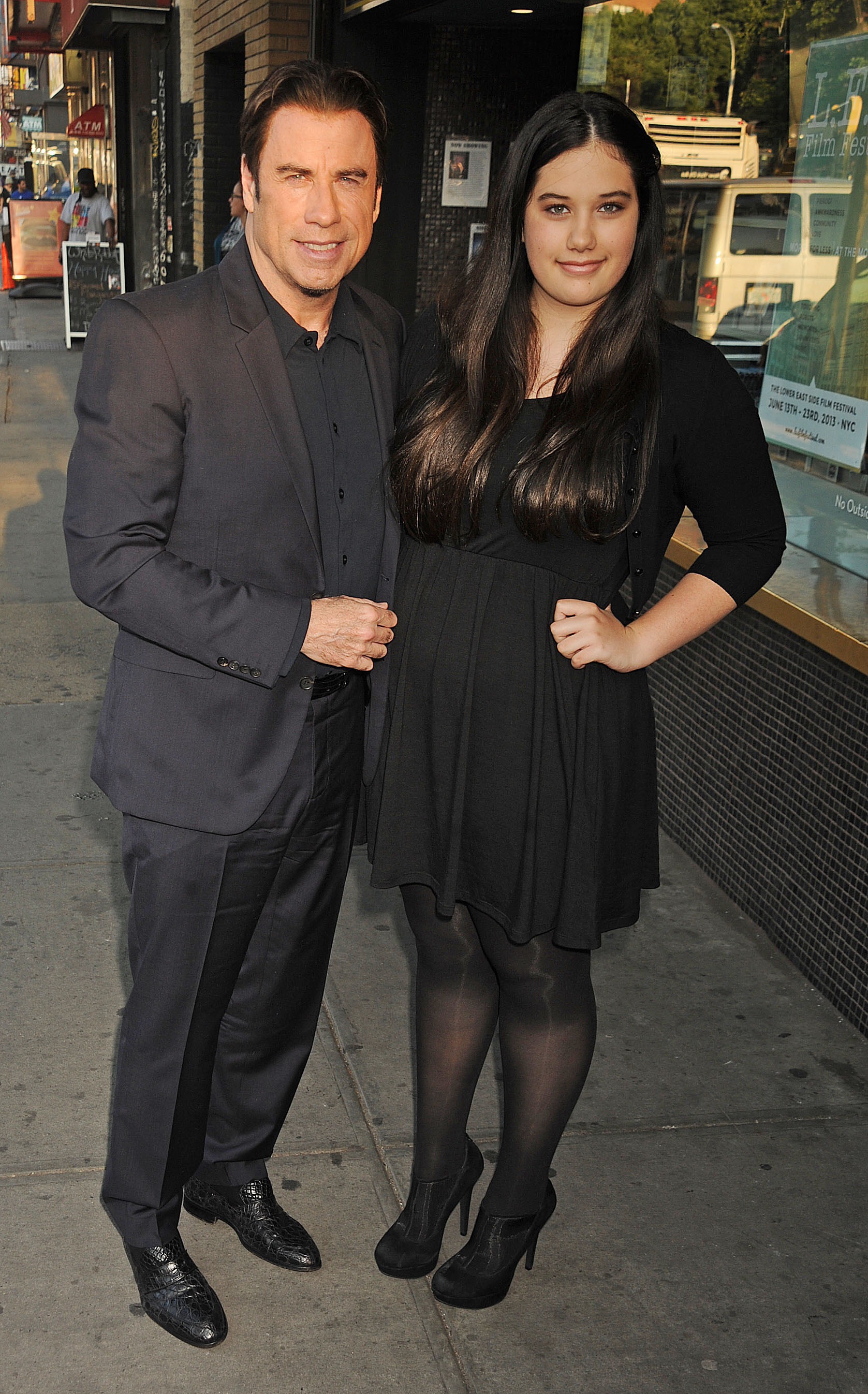 John Travolta stands beside Ella Bleu Travolta on a New York City sidewalk in 2013. Dressed in black, Ella appears more grown-up here, marking one of the pair's public father-daughter appearances.
