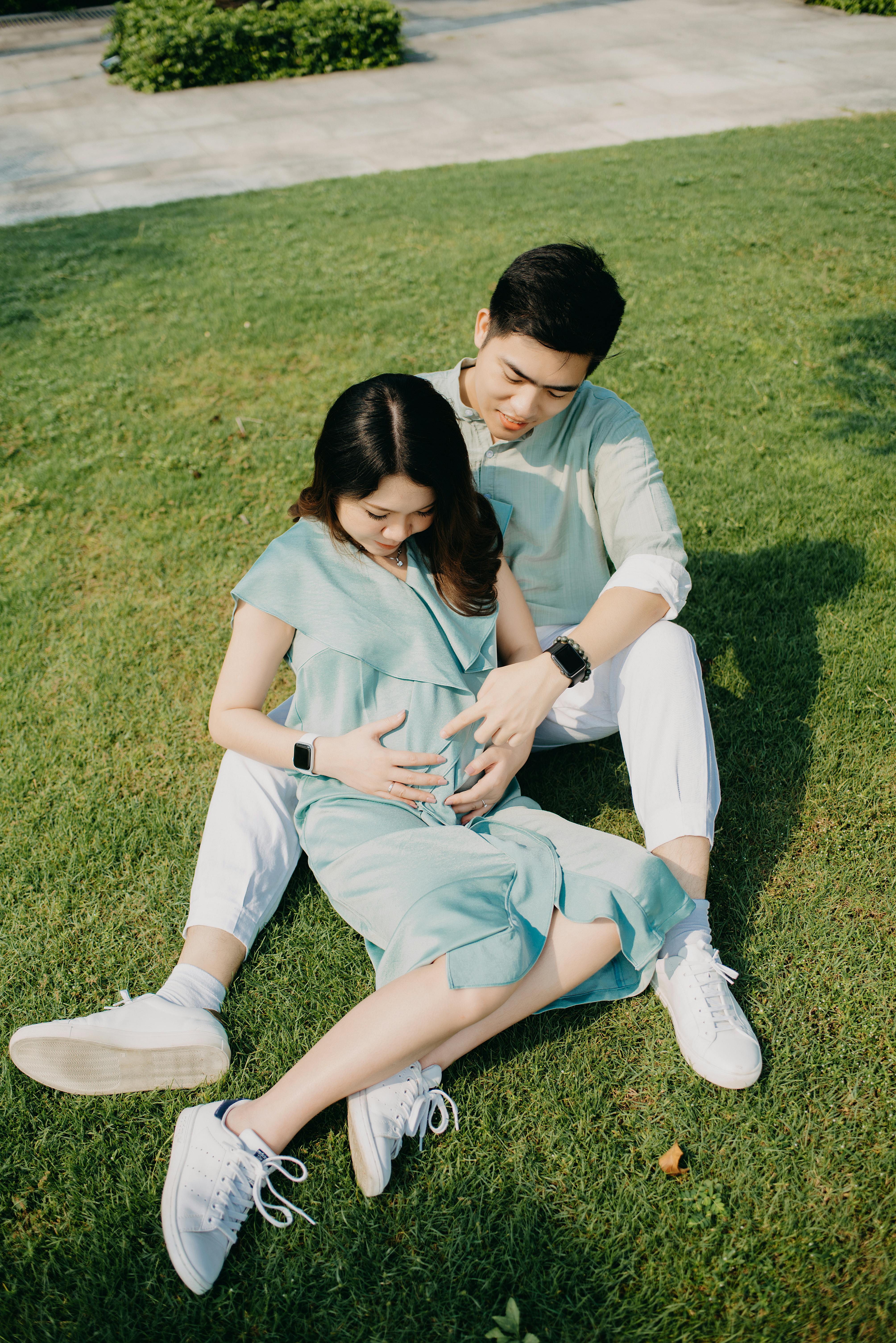 A couple resting on green lawn | Source: Pexels