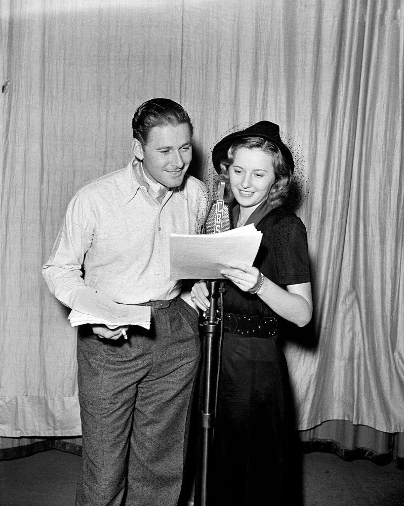 Actress Barbara Stanwyck and actor Errol Flynn record a script at the CBS Studios in Los Angeles, California. | Photo: Getty Images
