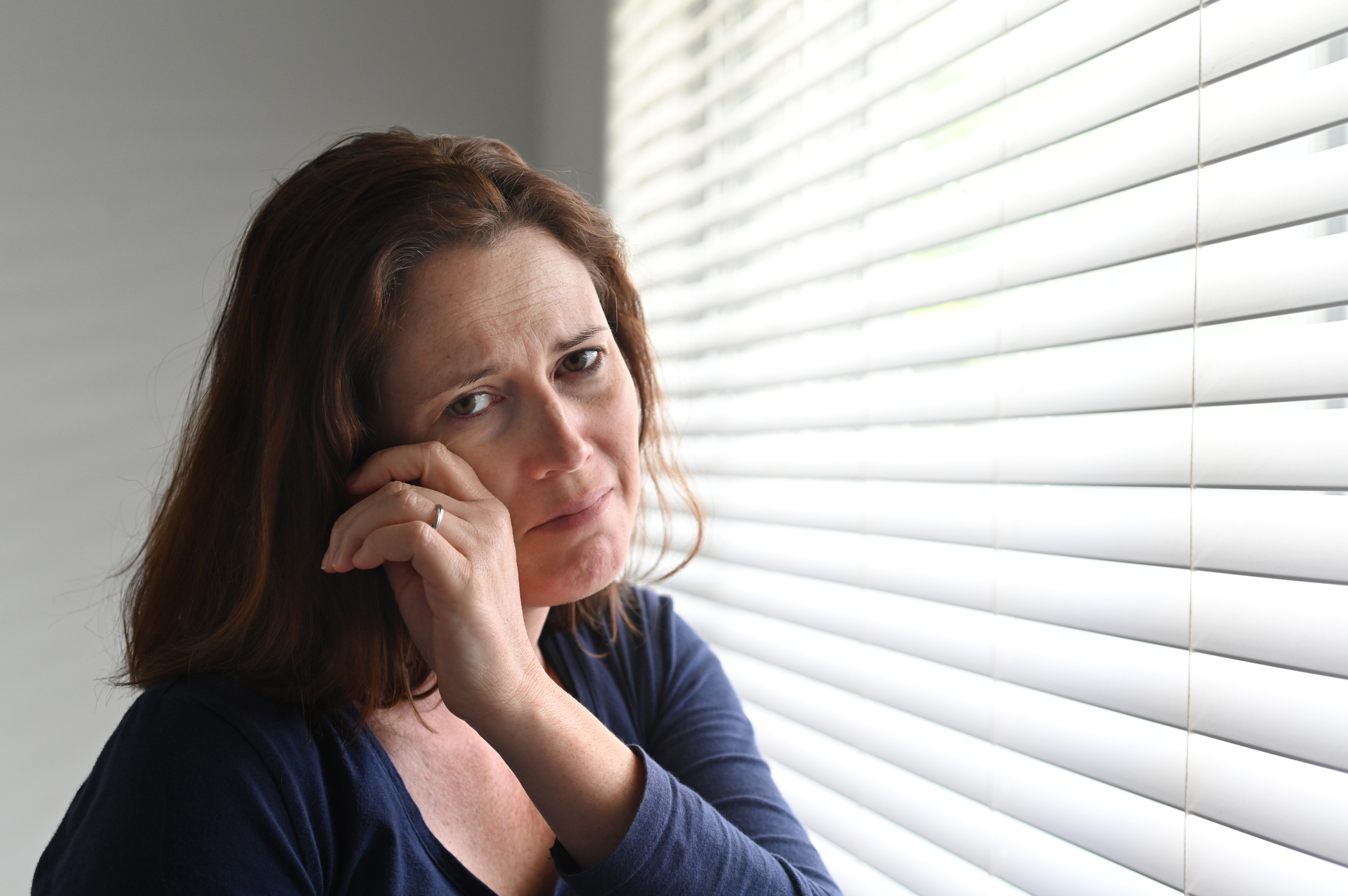 Sad crying woman near the window | Source: Shutterstock.com