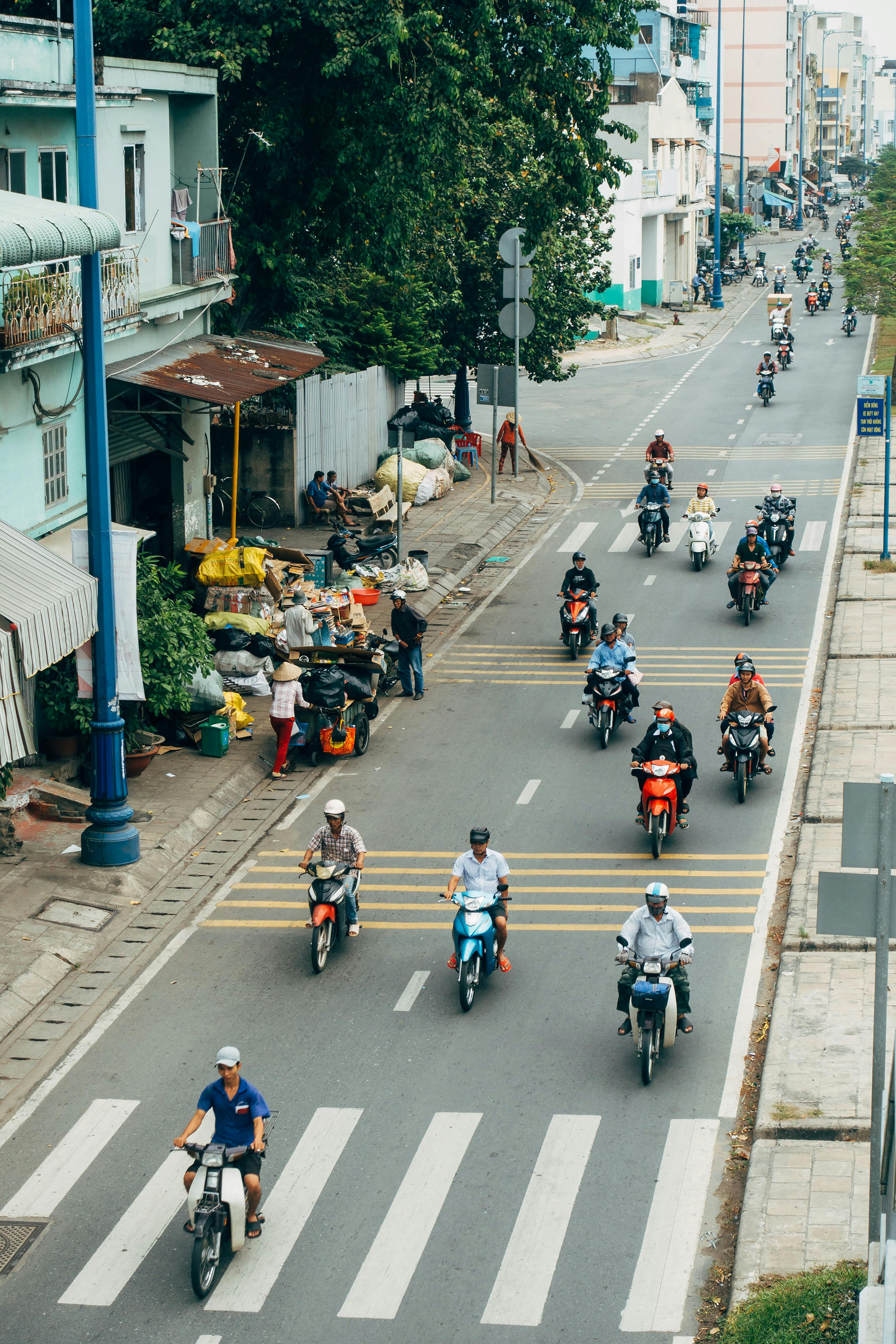 A group of people riding motorcycles down a city street in Hồ Chí Minh, Vietnam. | Source: Pexels